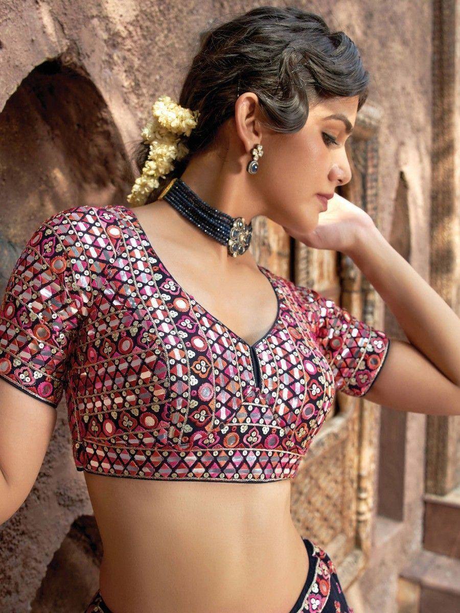 Woman in embroidered ethnic blouse with mirror work, floral hair accessory, and choker necklace