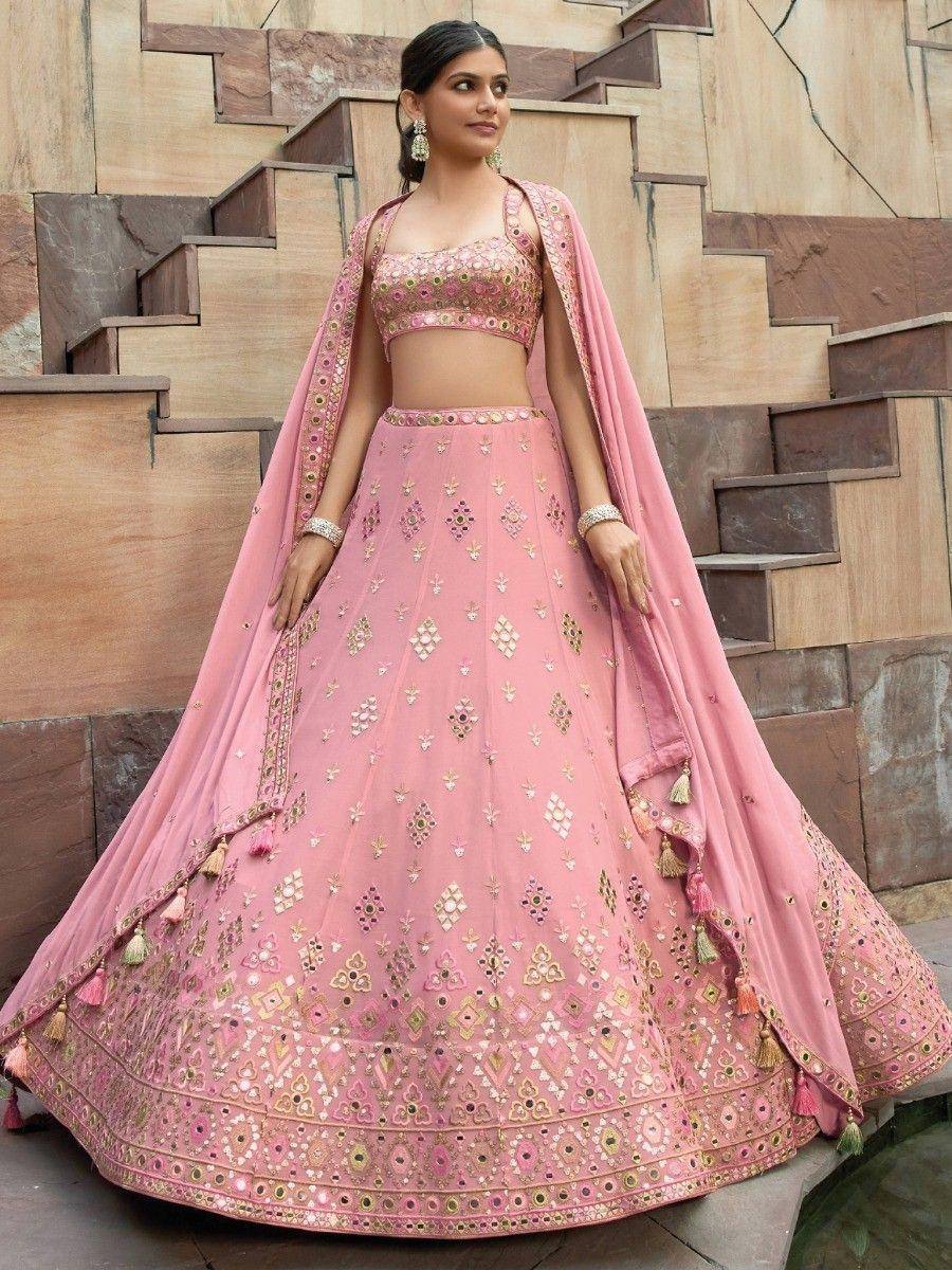 Pink designer lehenga choli with gold embroidery and tassels, perfect for Indian weddings and festive occasions