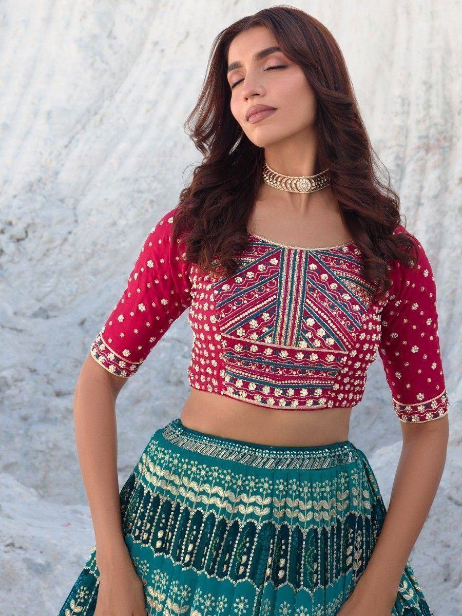 Red and teal embroidered lehenga choli with gold detailing, perfect for Indian ethnic wear