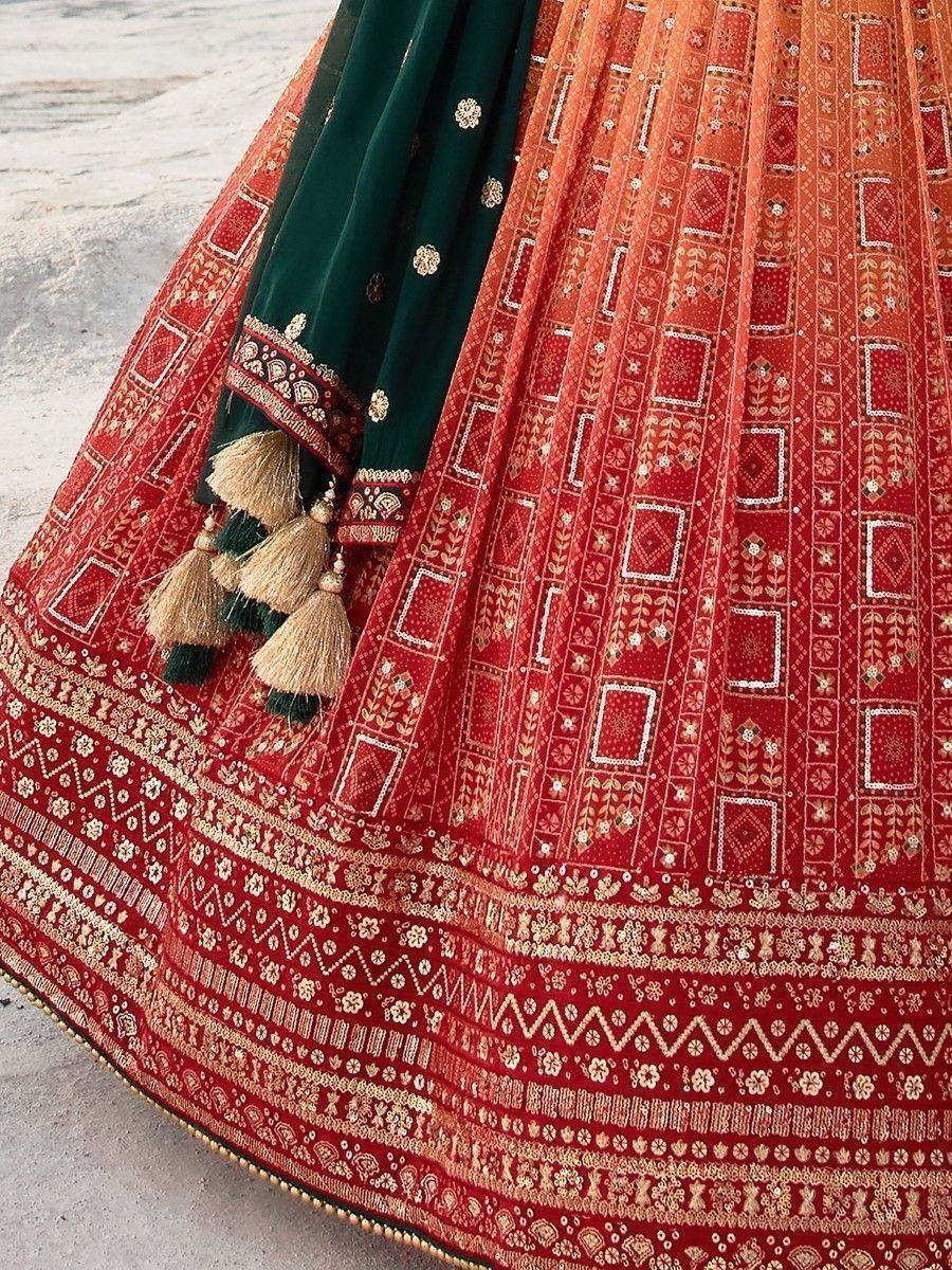 Red and green designer lehenga choli with intricate embroidery and tassels, perfect for Indian ethnic wear.