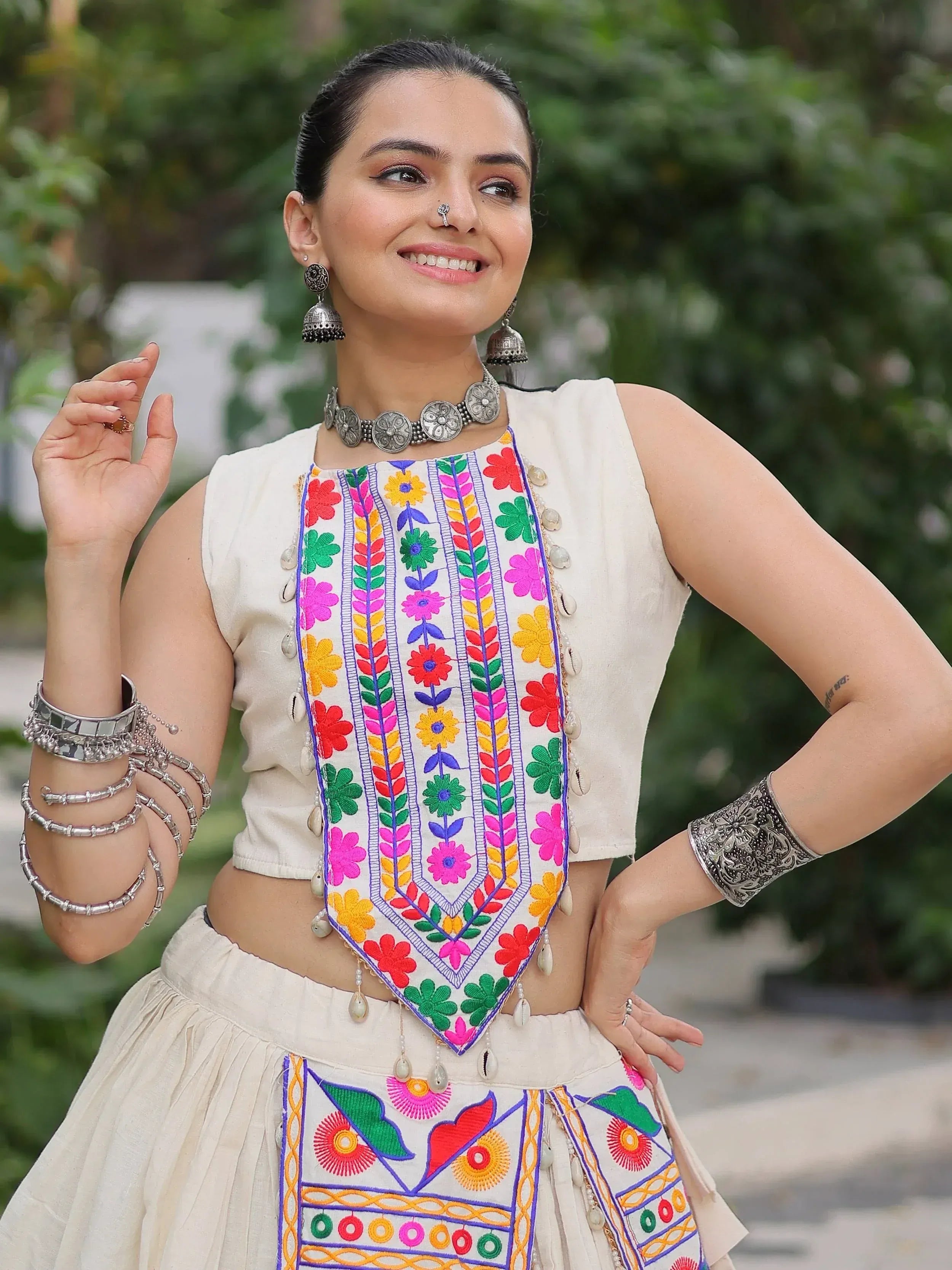Colorful embroidered ethnic wear with floral patterns and traditional jewelry