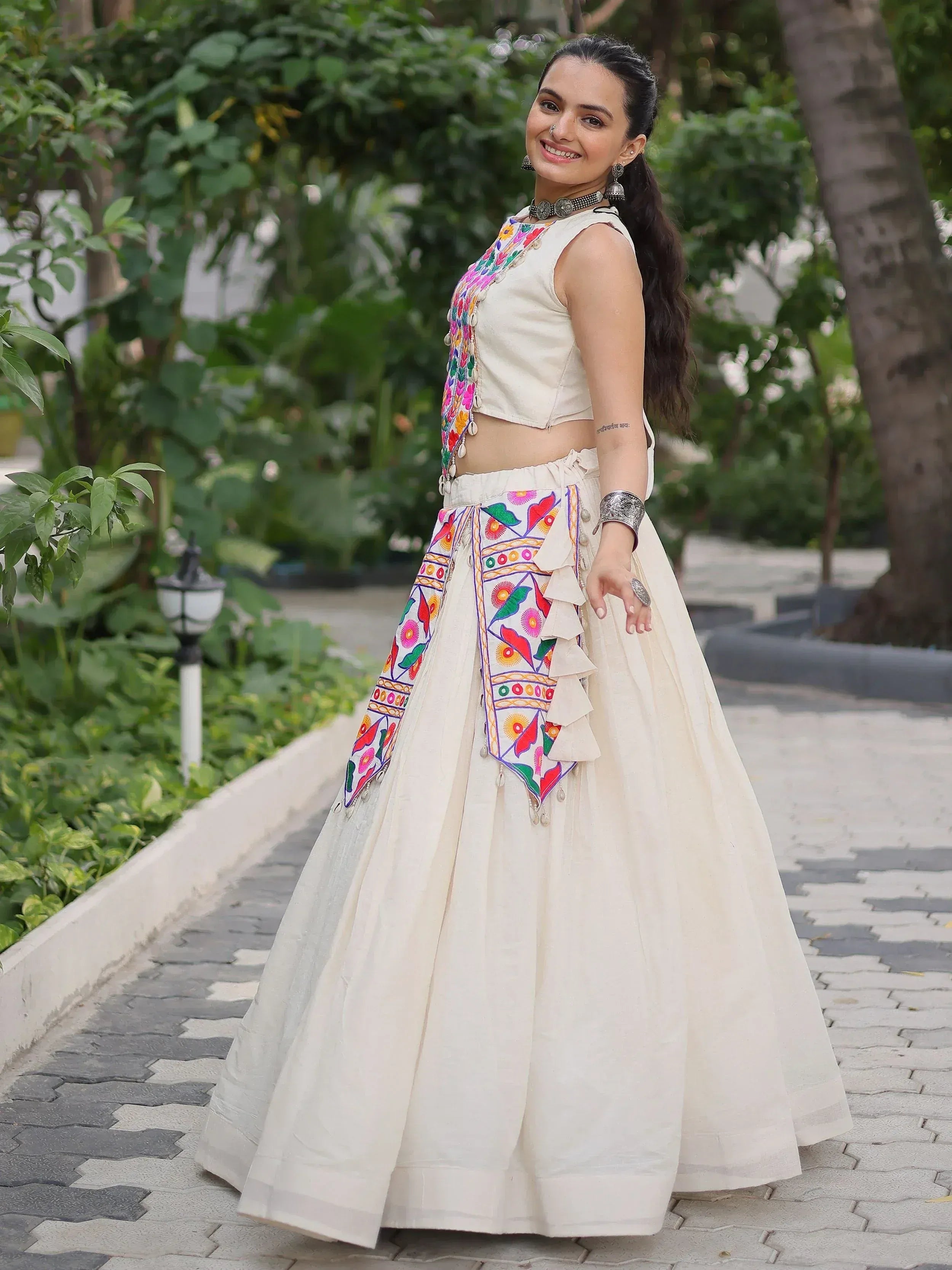 Woman in cream ethnic lehenga choli with colorful floral embroidery, perfect for Indian festivals and weddings