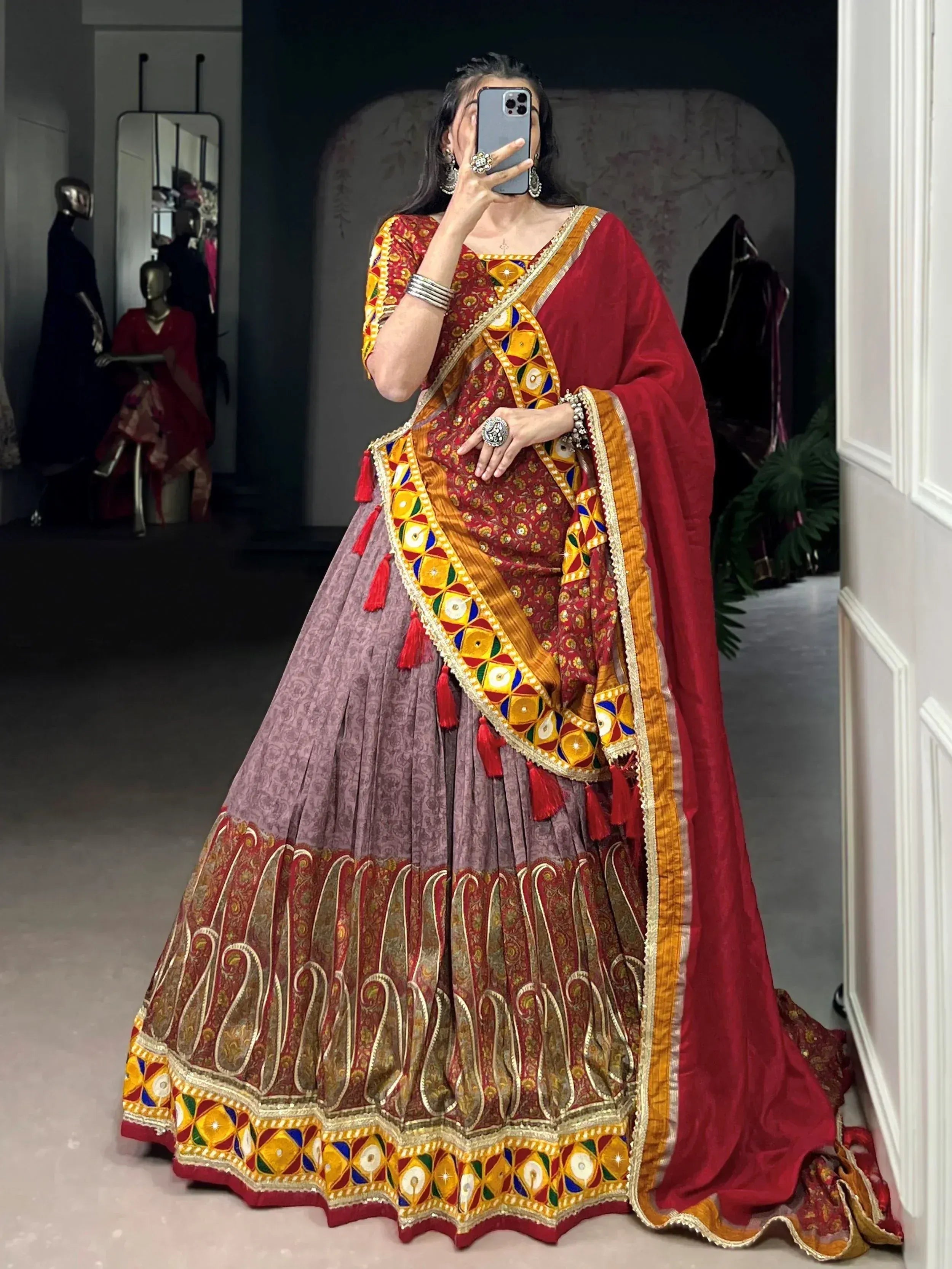 Woman in vibrant red and gold embroidered lehenga choli with mirror work, perfect for Indian ethnic occasions