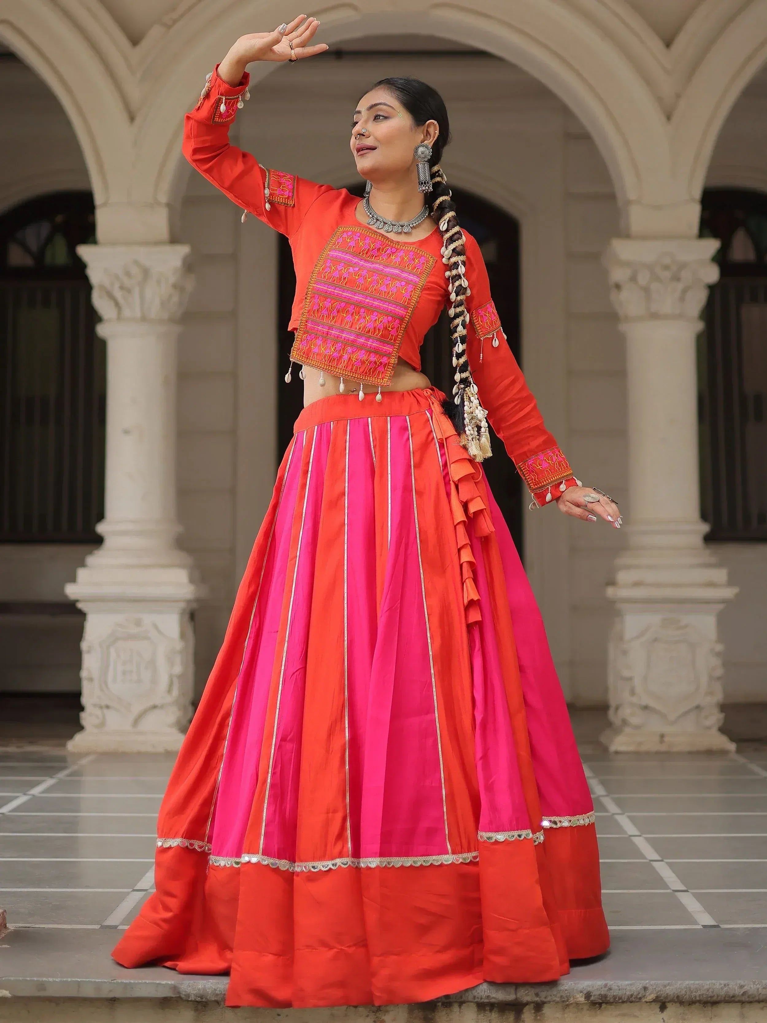 Vibrant red and pink embroidered lehenga choli with mirror work, perfect for Indian ethnic wear occasions.