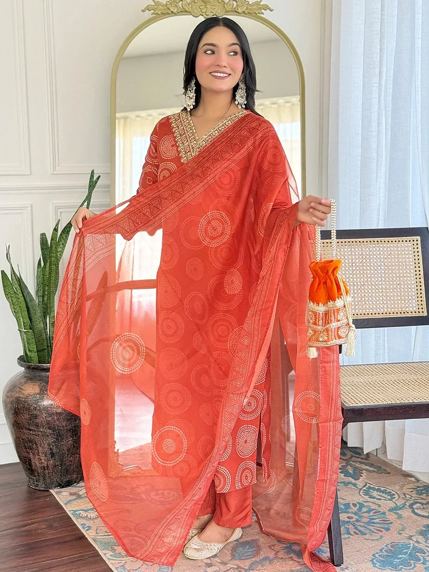 Orange printed salwar kameez with gold embroidery, matching dupatta and potli bag, Indian ethnic wear