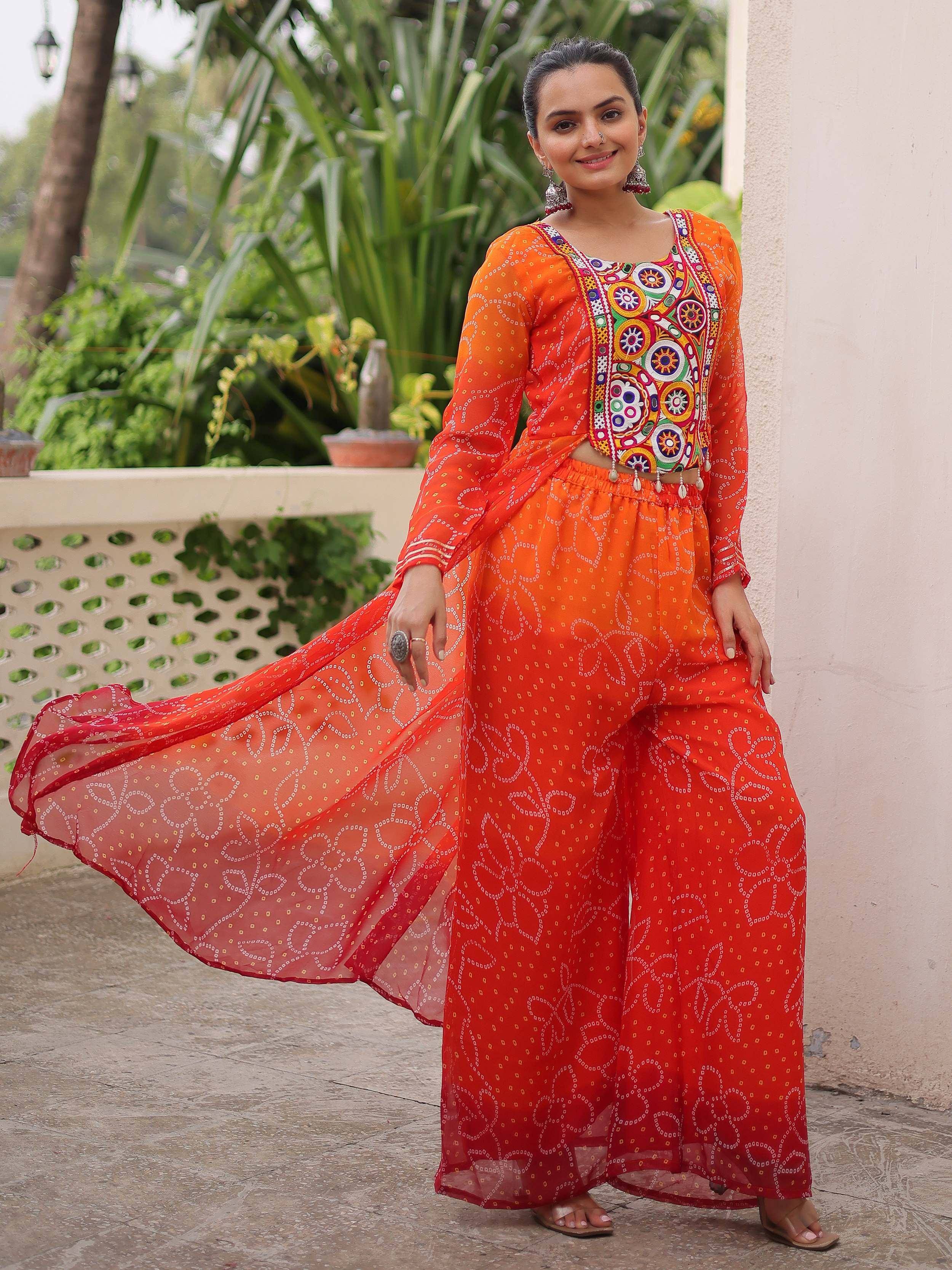 Vibrant orange ethnic palazzo set with mirror work blouse and printed dupatta, perfect for Indian occasions