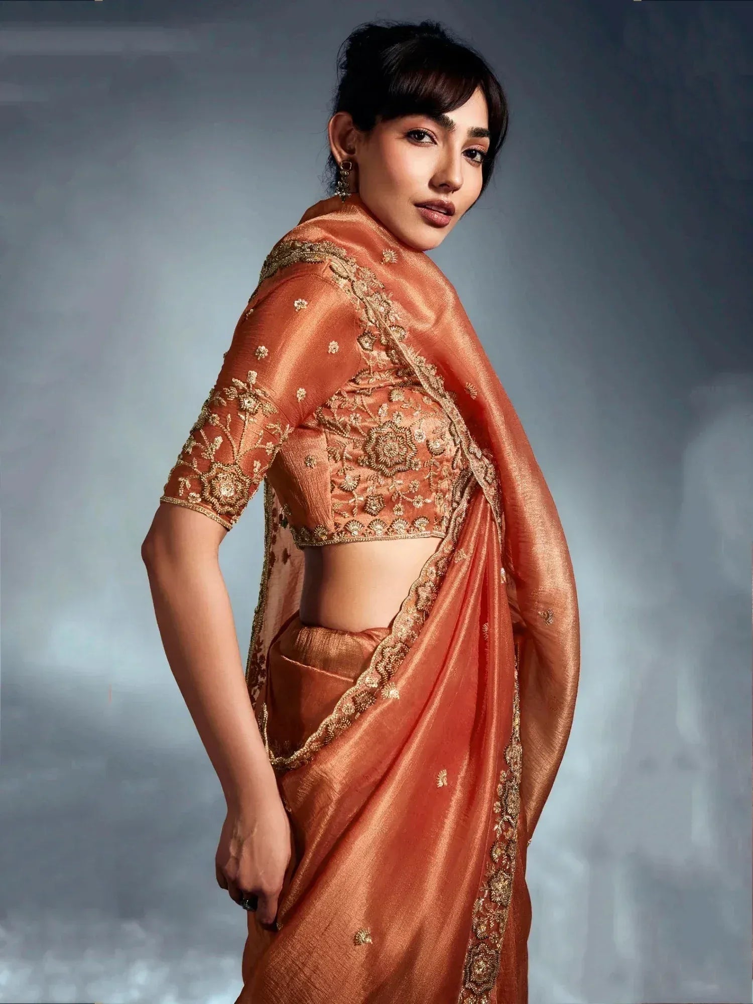 Elegant peach saree with golden embroidery, perfect for Indian ethnic wear occasions.