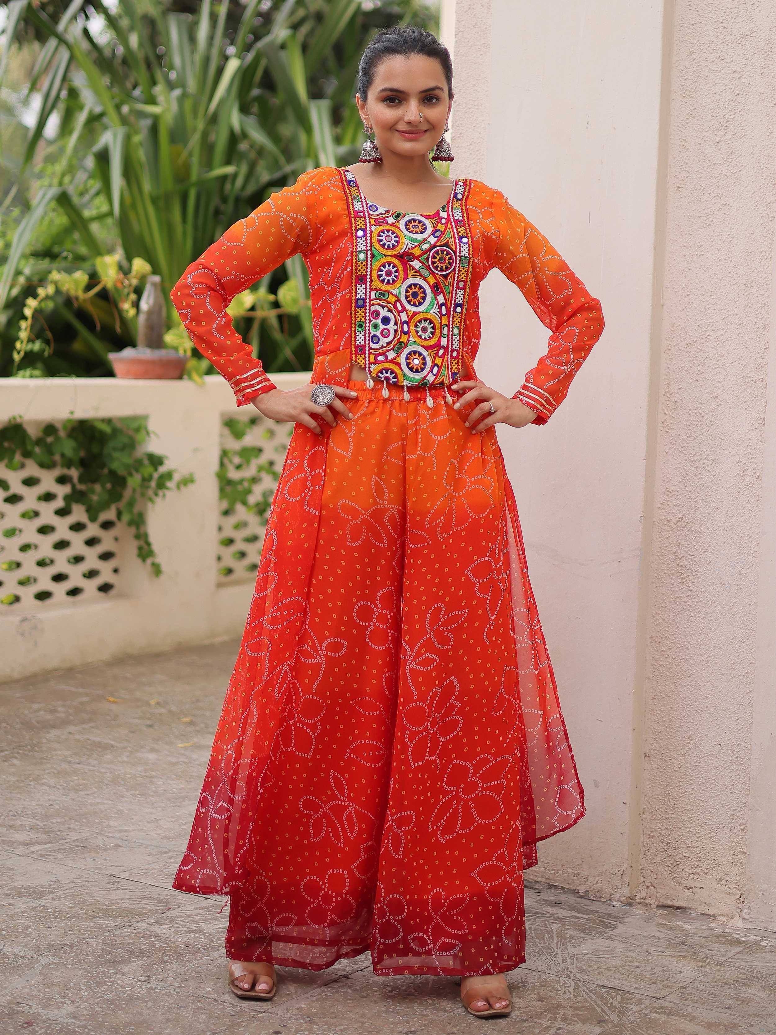 Vibrant orange ethnic sharara set with mirror work and bandhani print, perfect for festive occasions