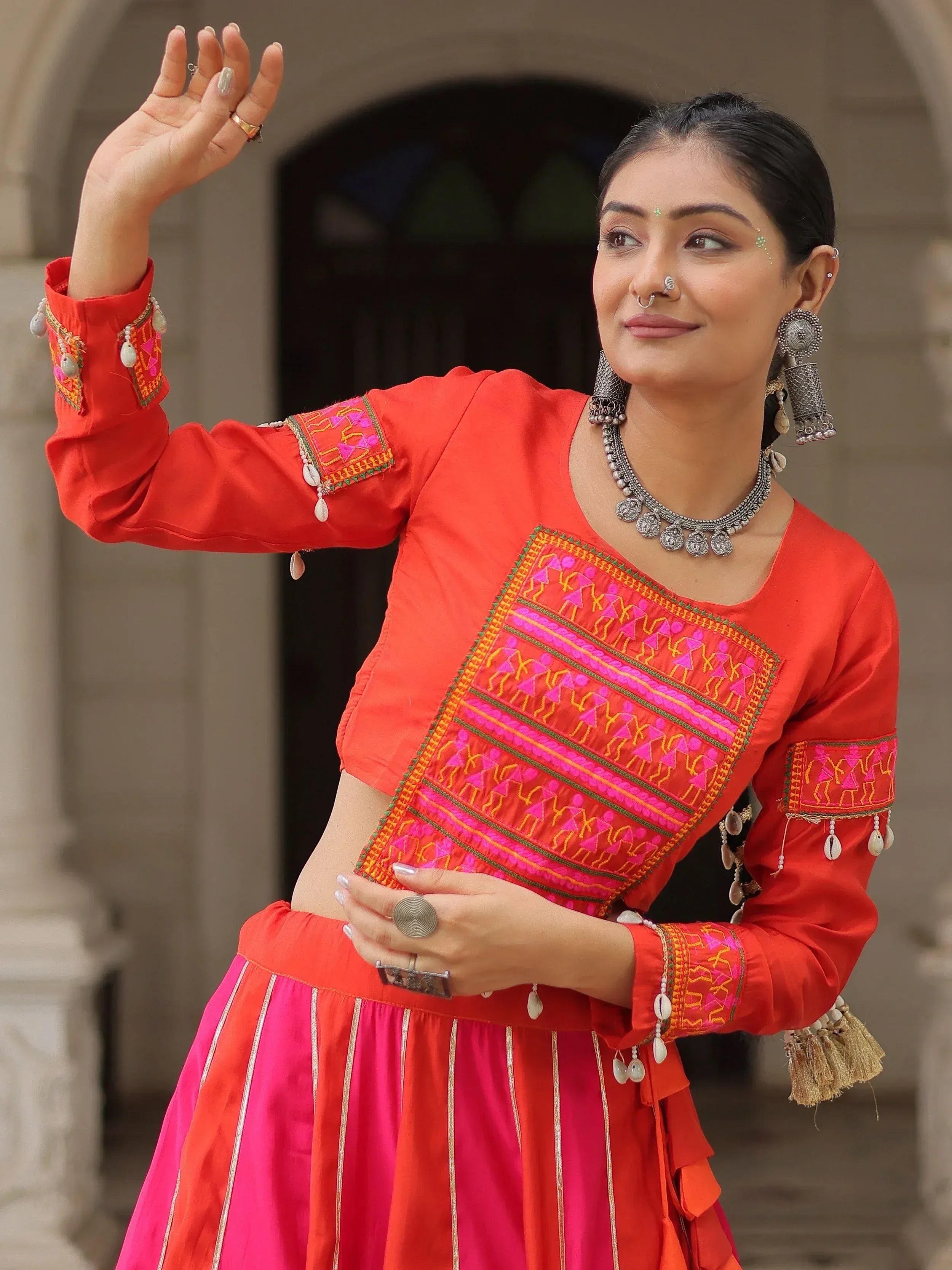 Vibrant red and pink embroidered ethnic lehenga choli with traditional jewelry