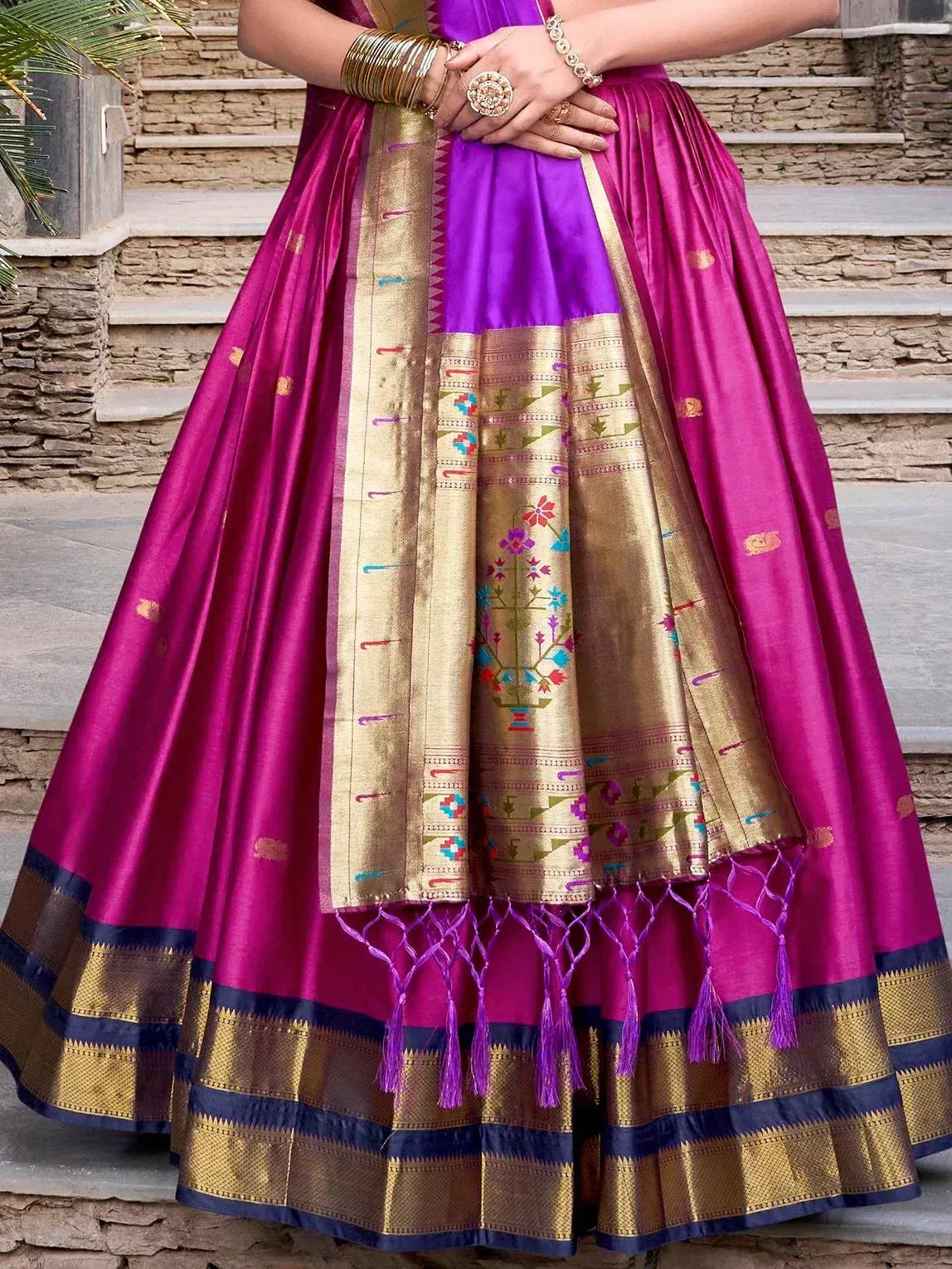 Purple and gold ethnic lehenga choli with floral embroidery and tassels, perfect for Indian weddings or festivals