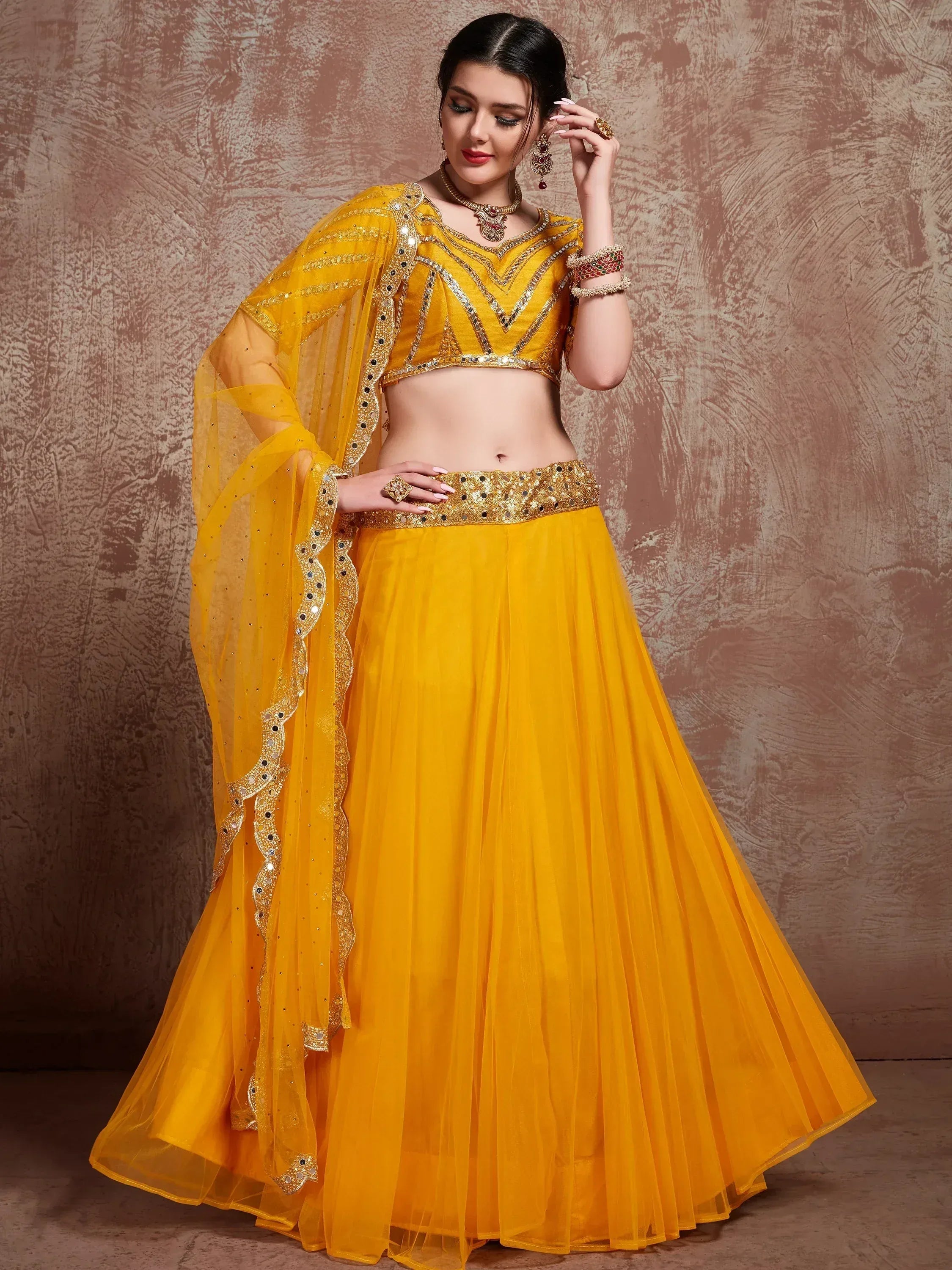 Yellow designer lehenga choli with mirror work and net dupatta for Indian ethnic wear