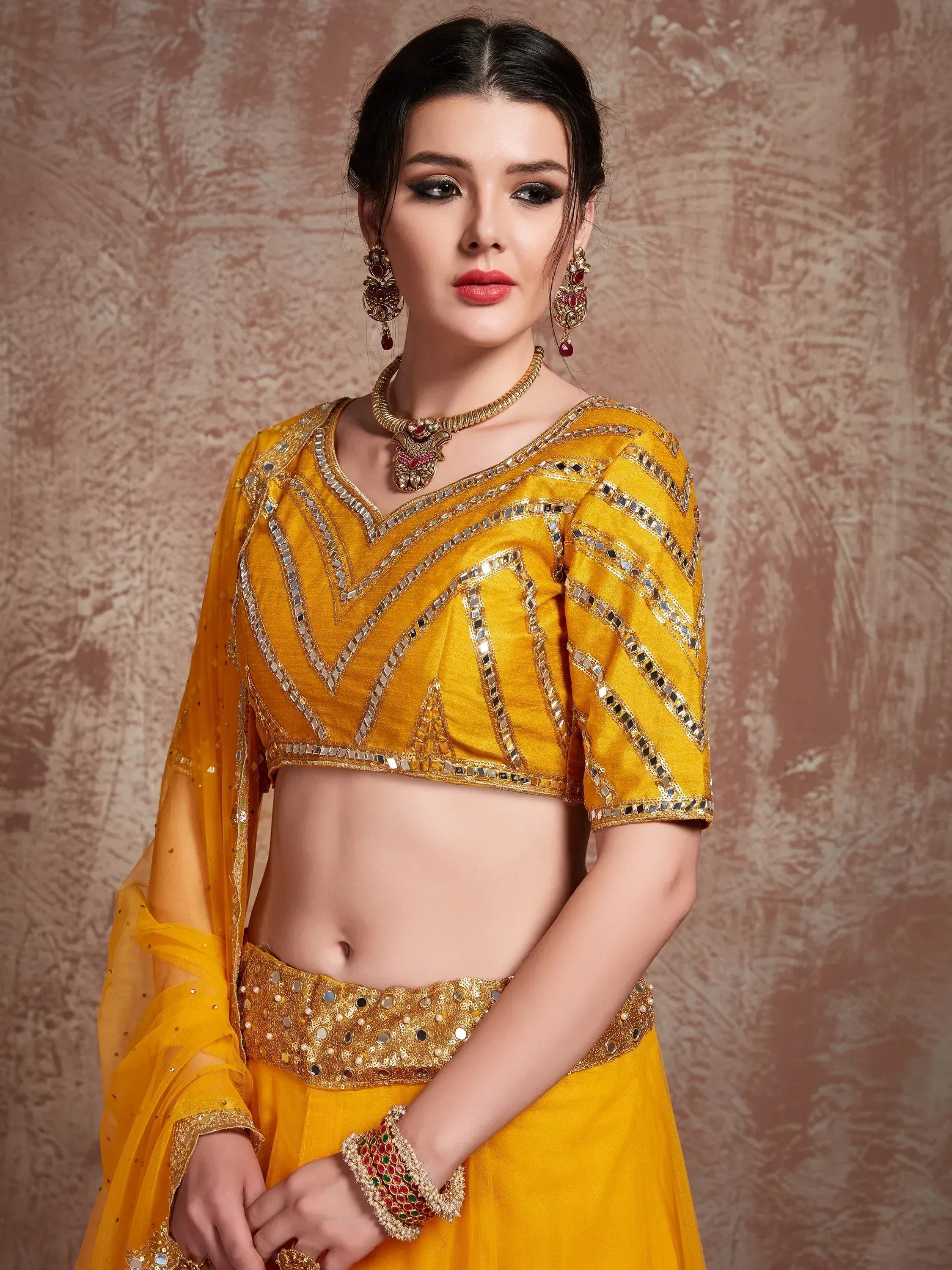 Yellow mirror-work lehenga choli with gold embroidery, perfect for Indian ethnic wear and festive occasions.