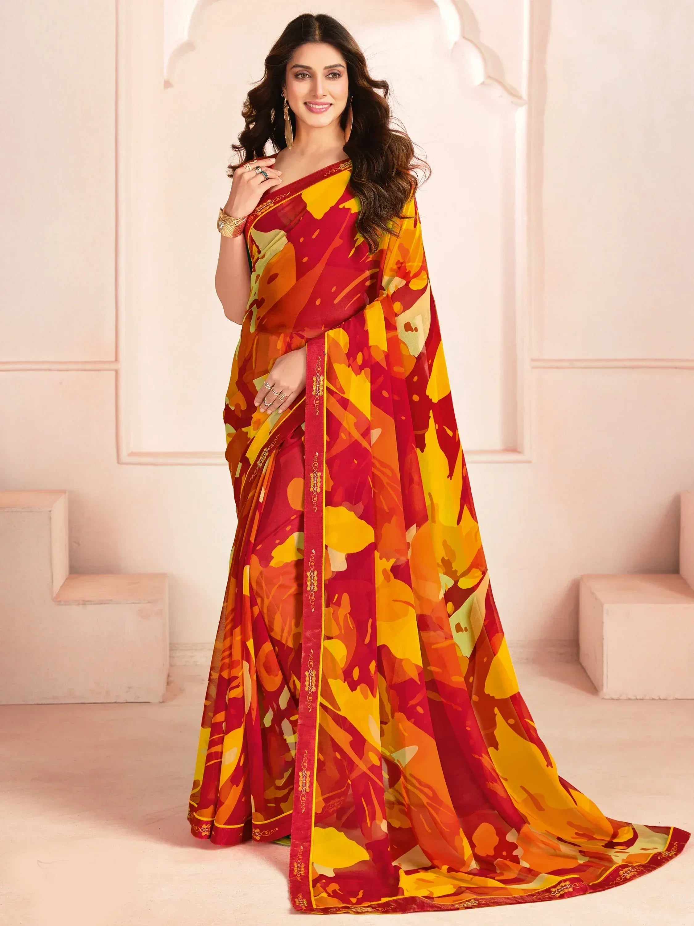 Vibrant red and yellow printed saree with gold border, styled for Indian ethnic wear occasions