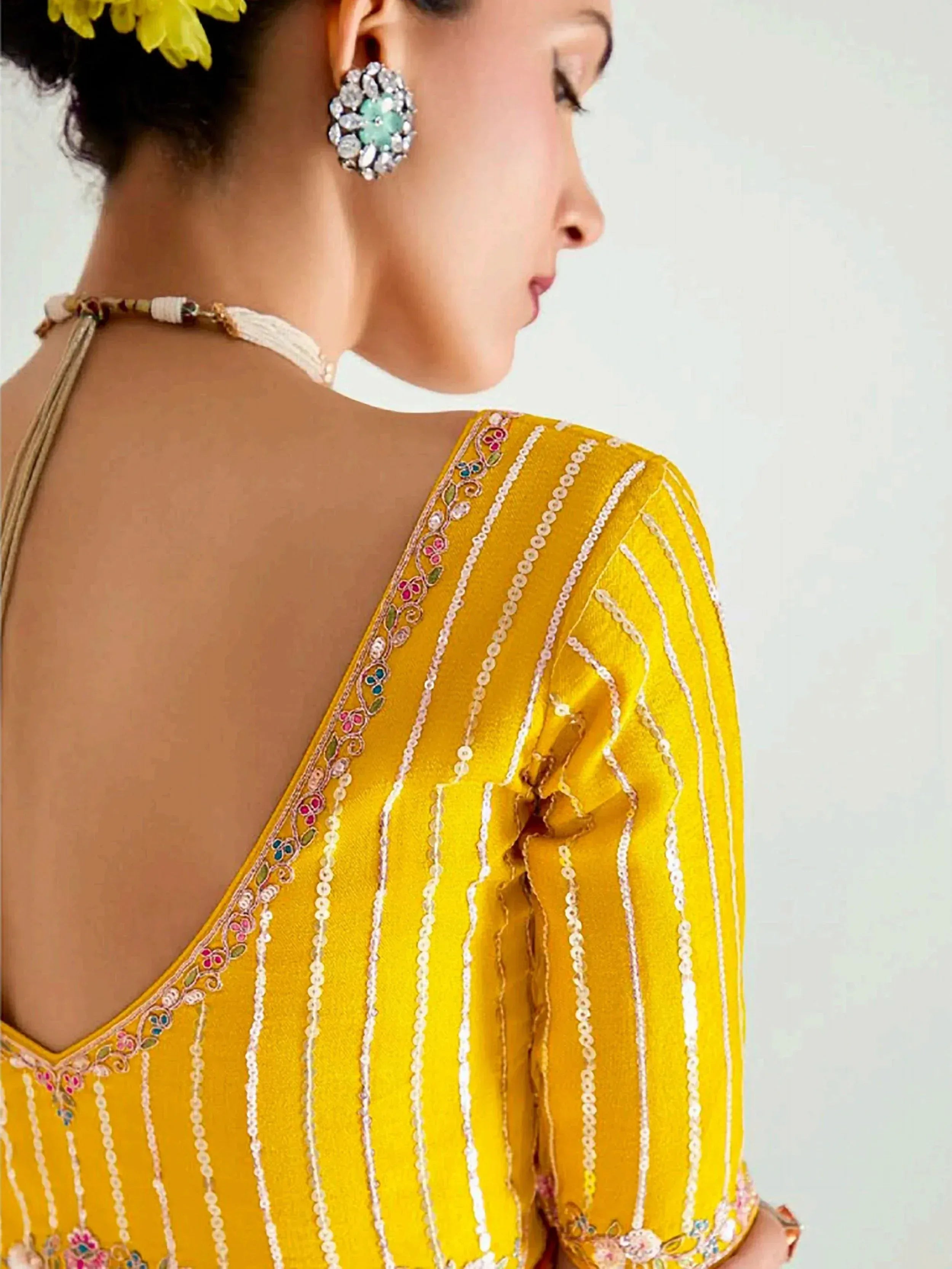 Yellow ethnic gown with sequin stripes, floral embroidery, and statement earrings for Indian wear