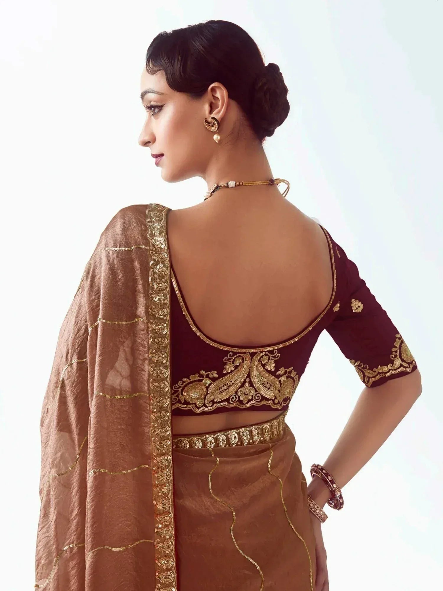 Maroon and gold embroidered saree blouse with backless design, paired with matching dupatta for ethnic wear