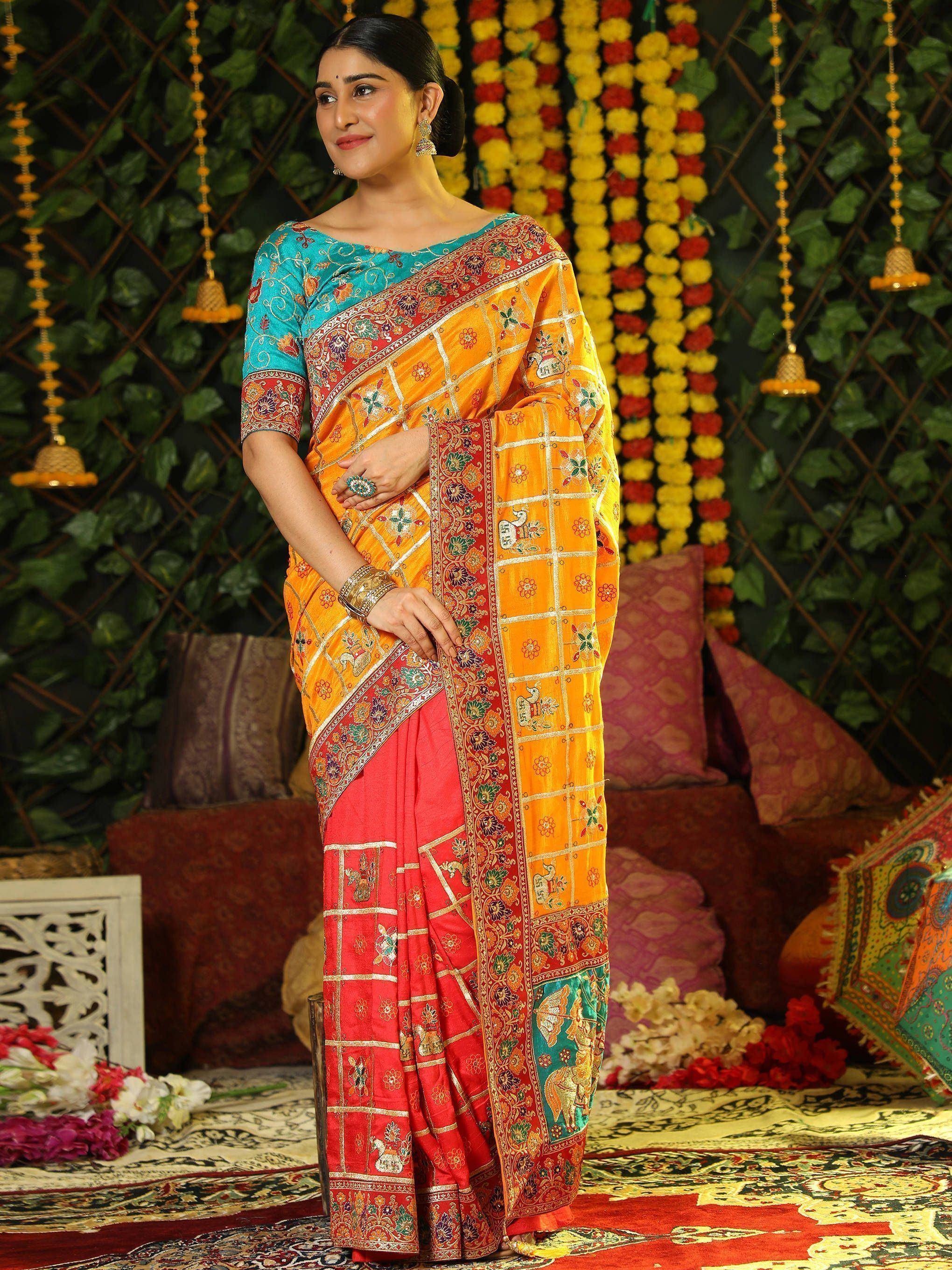 Woman in vibrant orange and red embroidered saree with peacock motifs, perfect for Indian ethnic occasions