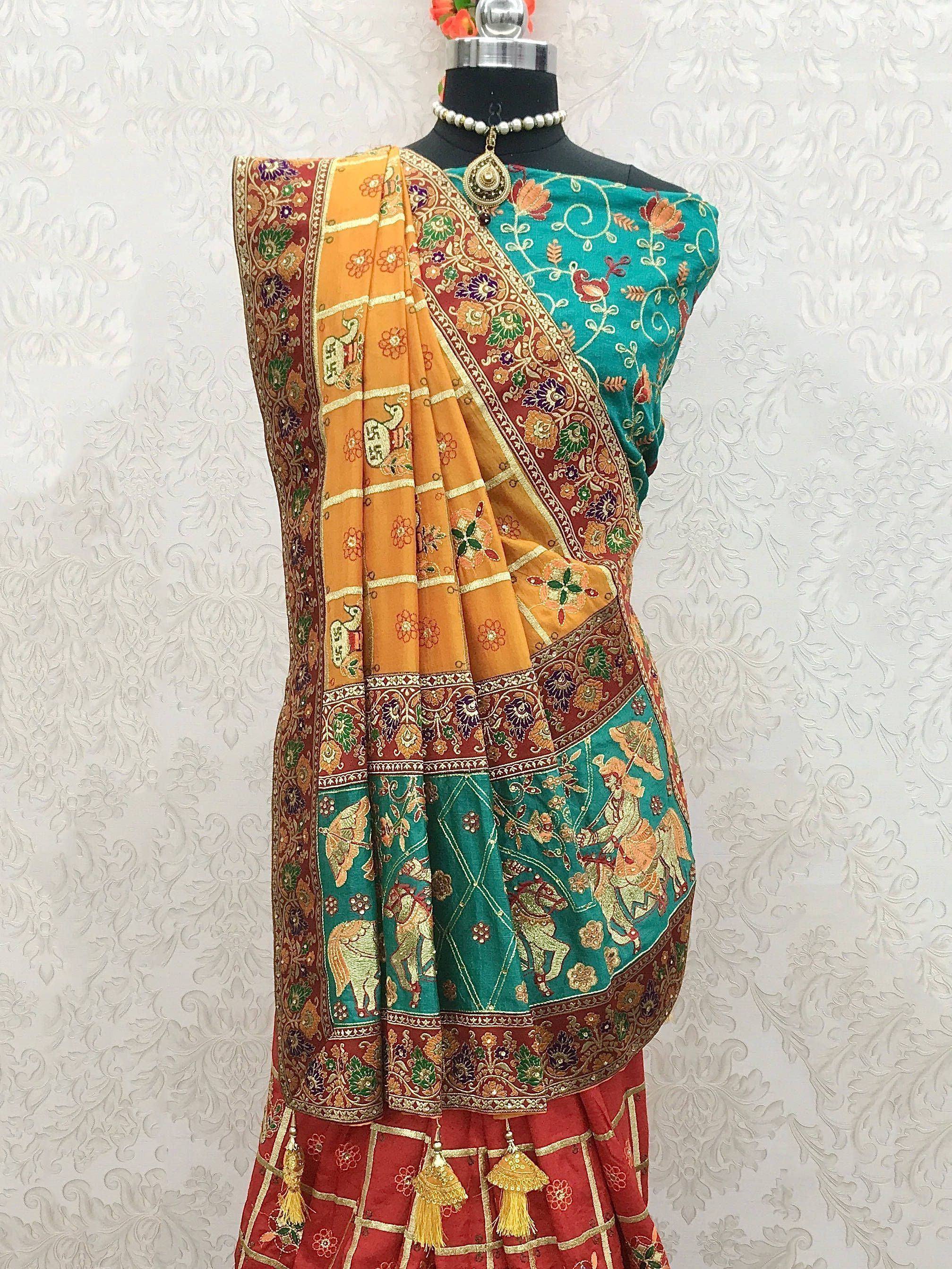 Teal and orange embroidered saree with floral and elephant motifs, paired with red lehenga, displayed on mannequin