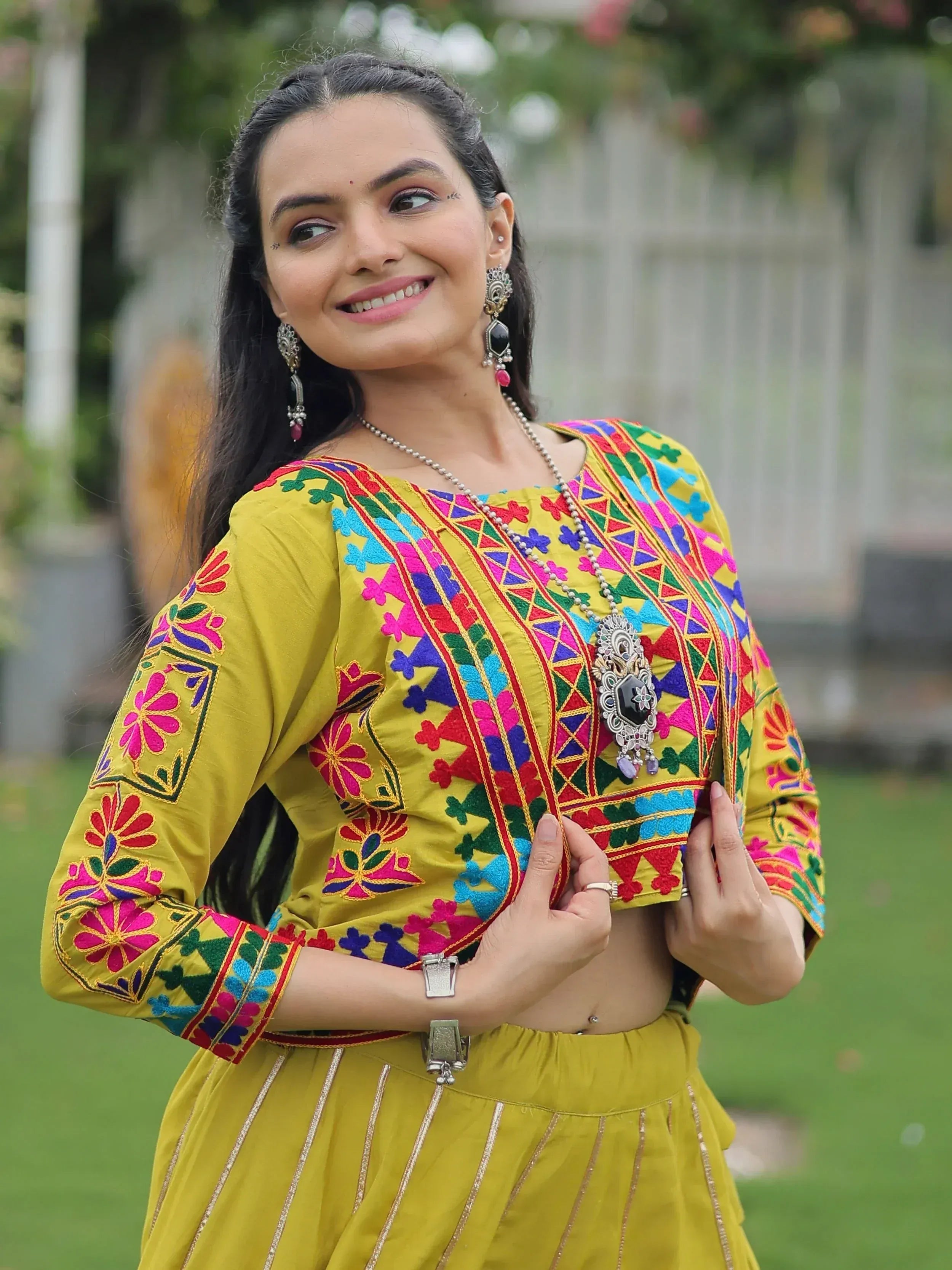 Woman in vibrant yellow embroidered ethnic top and skirt, floral patterns, traditional Indian wear