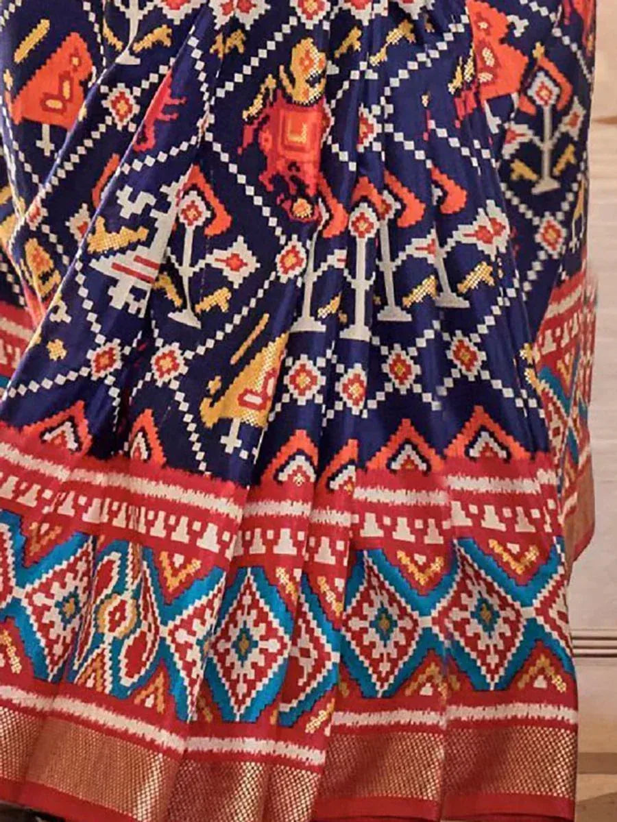 Vibrant ethnic saree with bold geometric and tribal print in navy, red, and gold tones