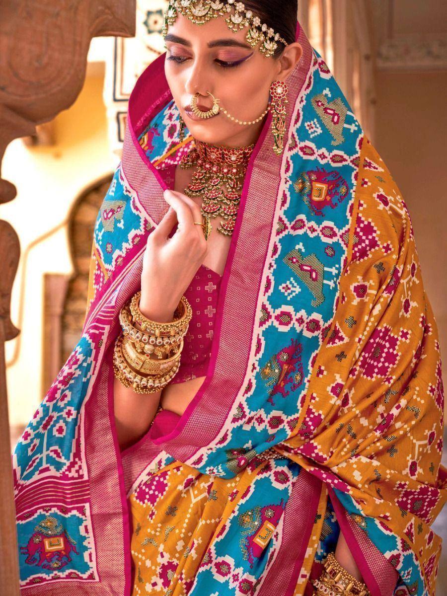 Woman in vibrant Indian ethnic saree with intricate embroidery and traditional gold jewelry