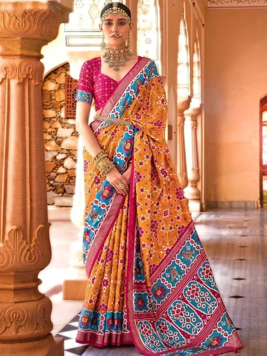 Woman in vibrant orange and blue printed saree with pink blouse, traditional Indian ethnic wear