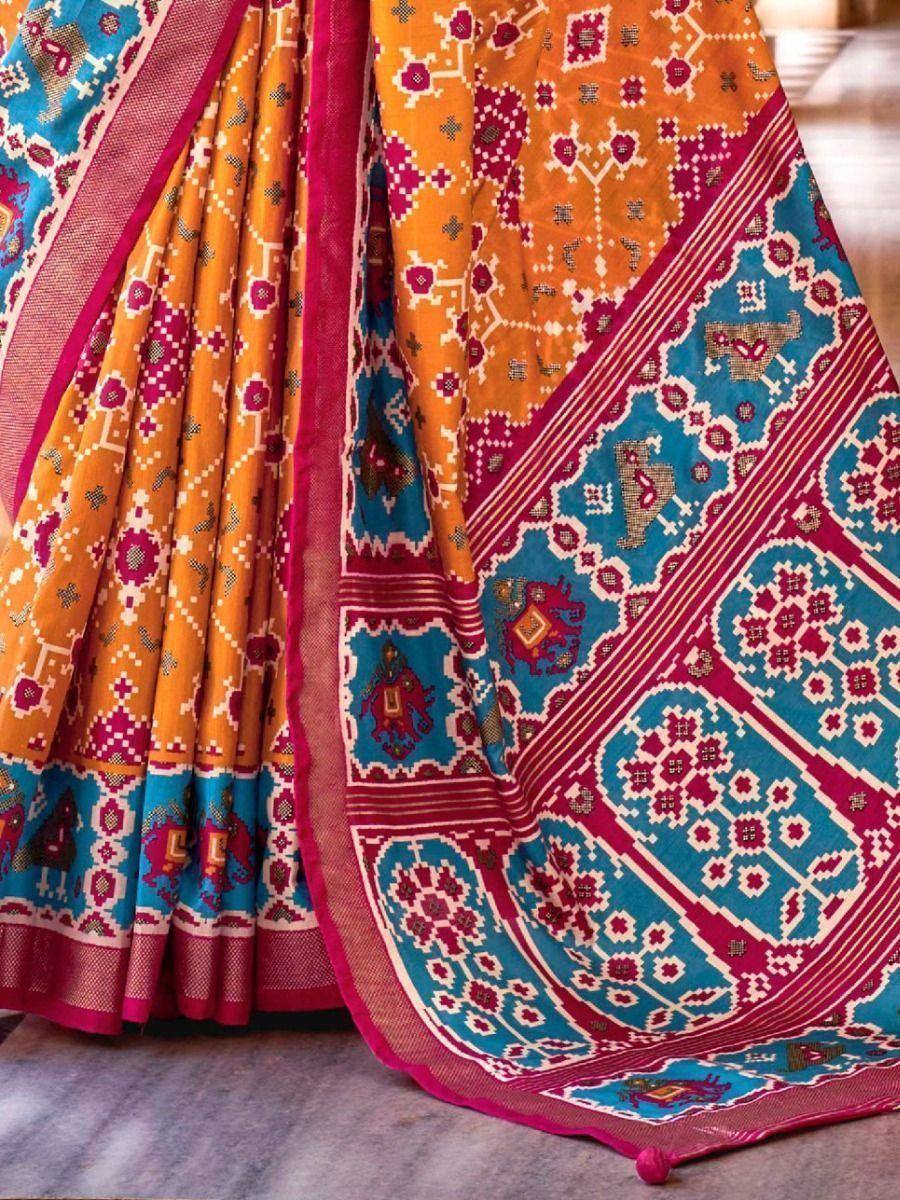 Vibrant orange and blue ethnic saree with intricate geometric and elephant motifs, perfect for festive occasions.