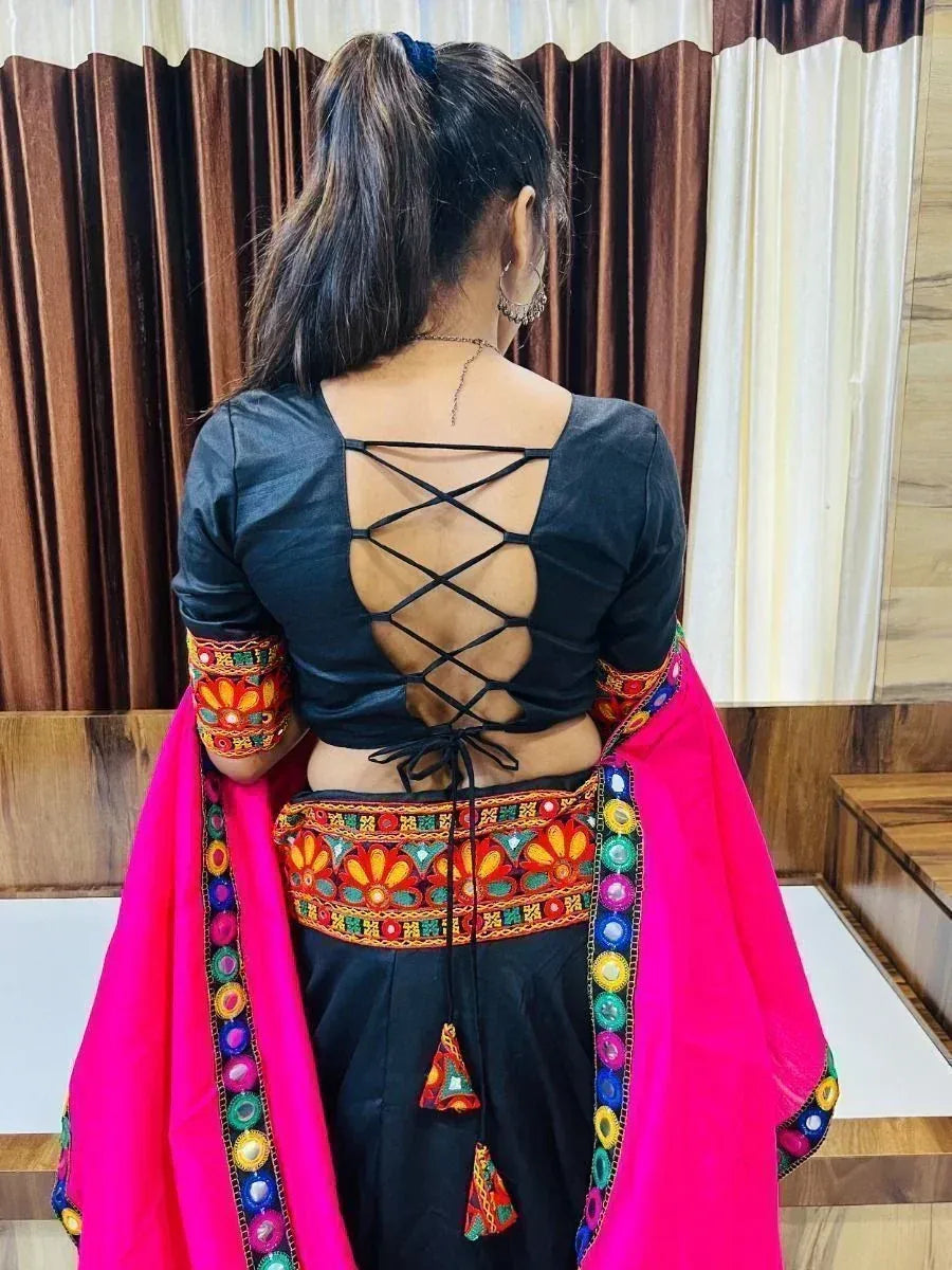 Black criss-cross back blouse with colorful embroidery, paired with pink dupatta and ethnic skirt