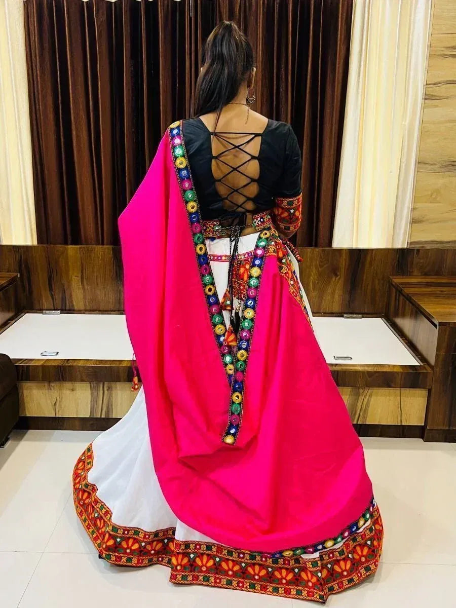 Woman in vibrant pink and white ethnic lehenga with colorful mirror work and crisscross back blouse