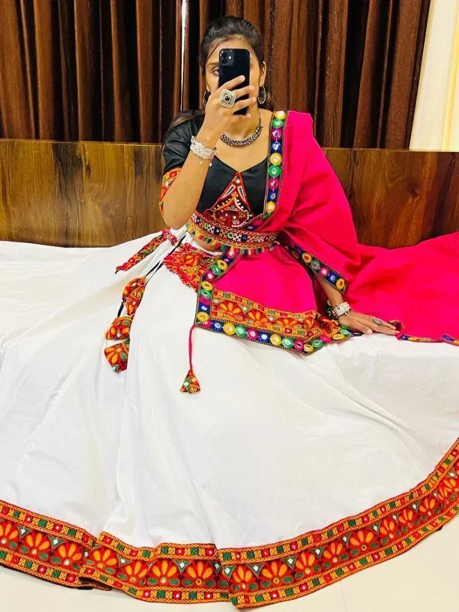Woman in vibrant pink and white embroidered lehenga choli with mirror work, taking mirror selfie