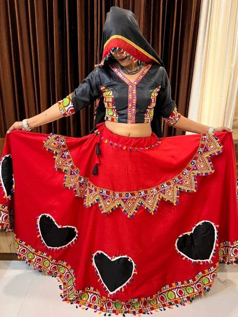 Red and black embroidered ethnic lehenga choli with heart cutouts and mirror work, perfect for festive occasions