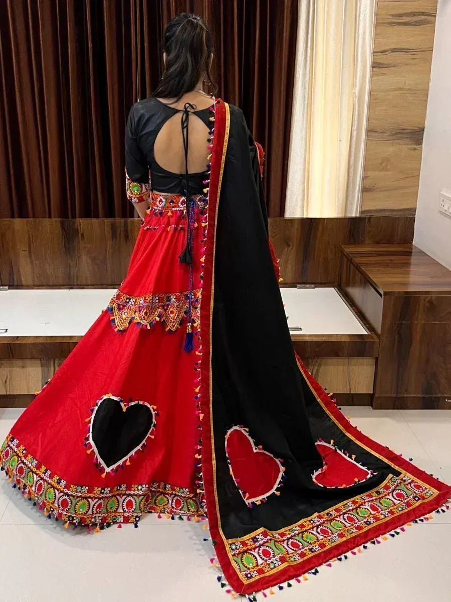 Red and black ethnic lehenga choli with heart cutouts, mirror work, and tassels, back view