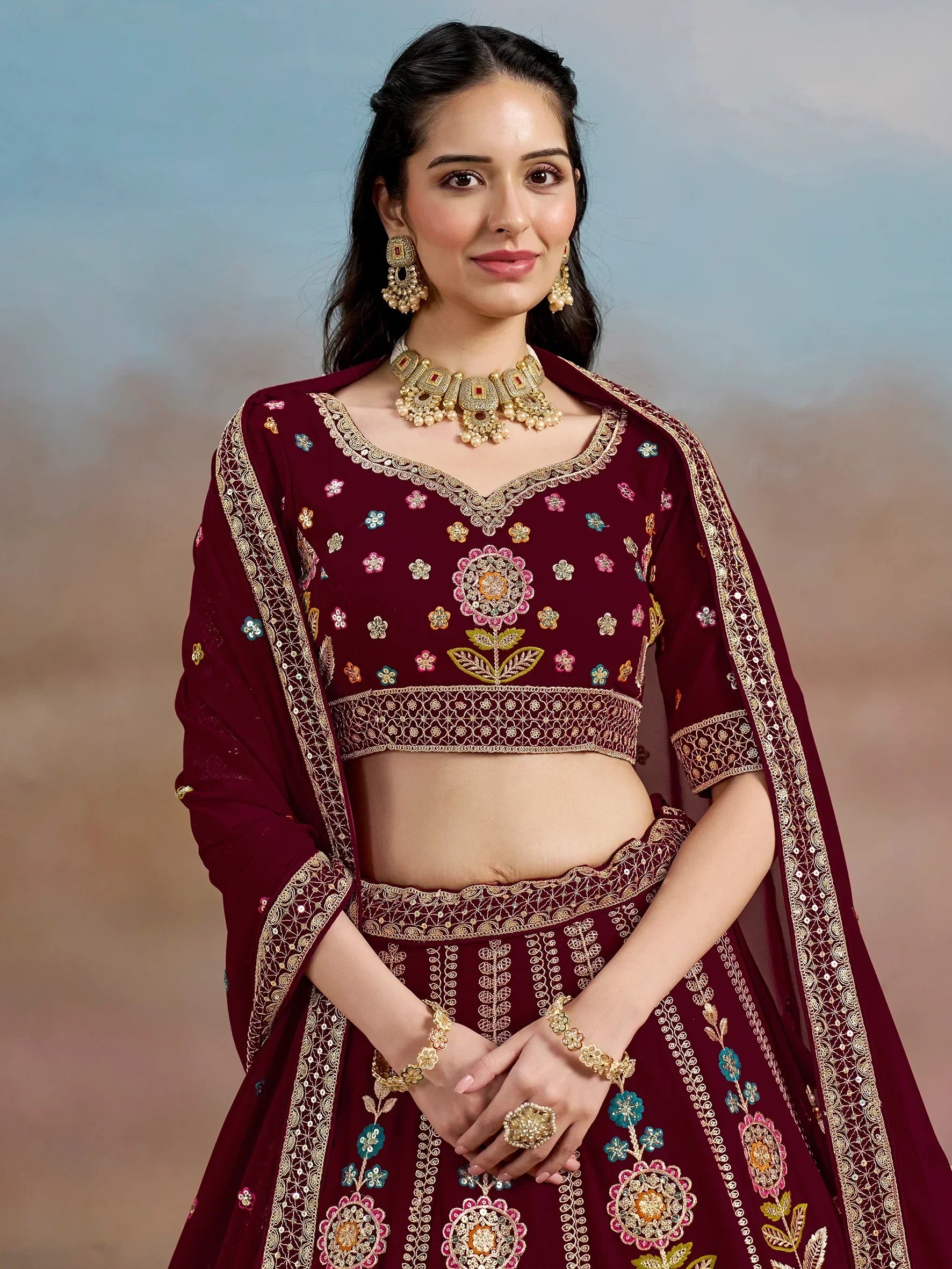 Maroon embroidered lehenga choli with floral motifs and gold detailing, perfect for Indian ethnic wear occasions.