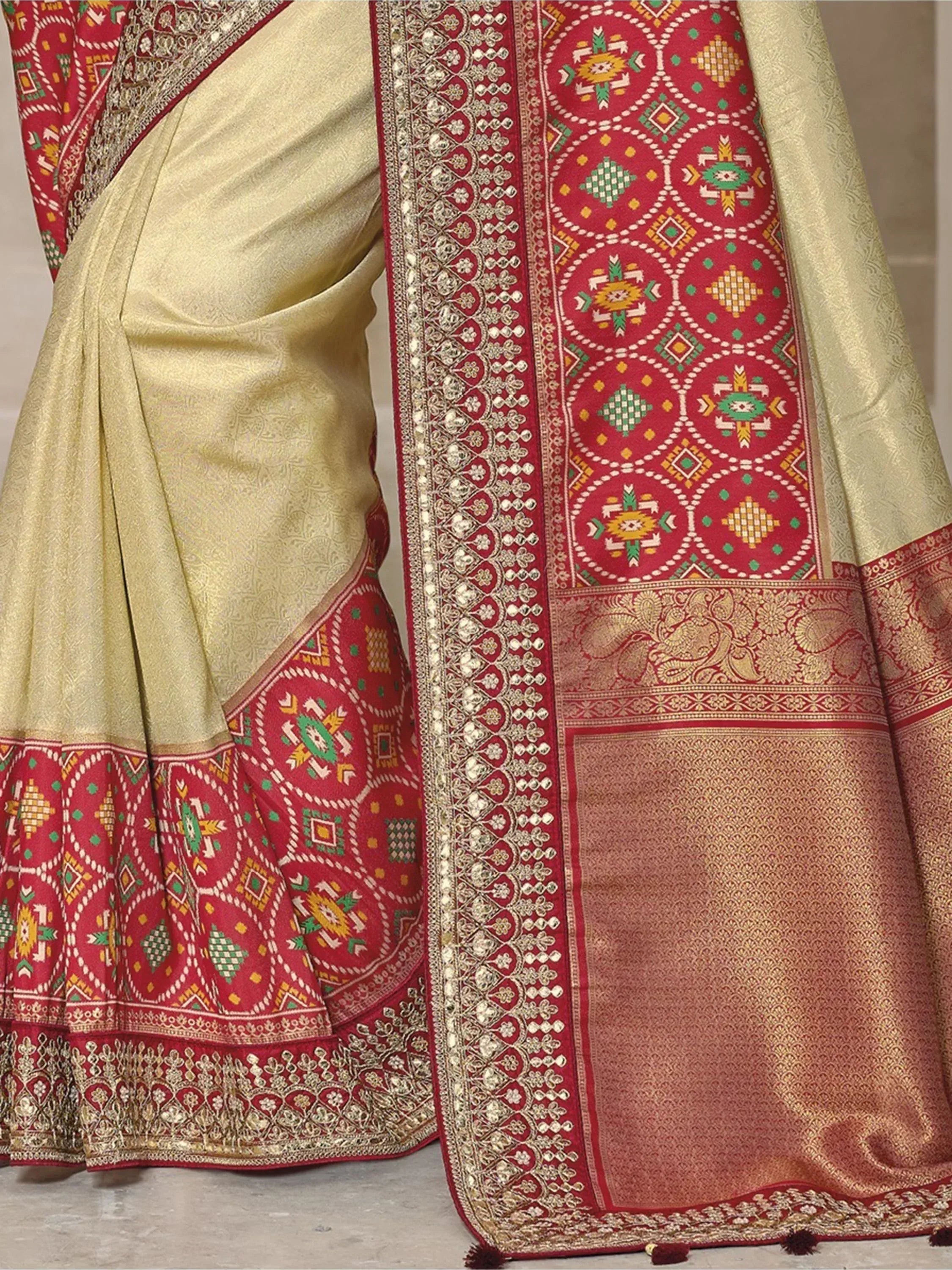 Cream and red ethnic saree with intricate geometric and floral embroidery, perfect for Indian festive occasions.