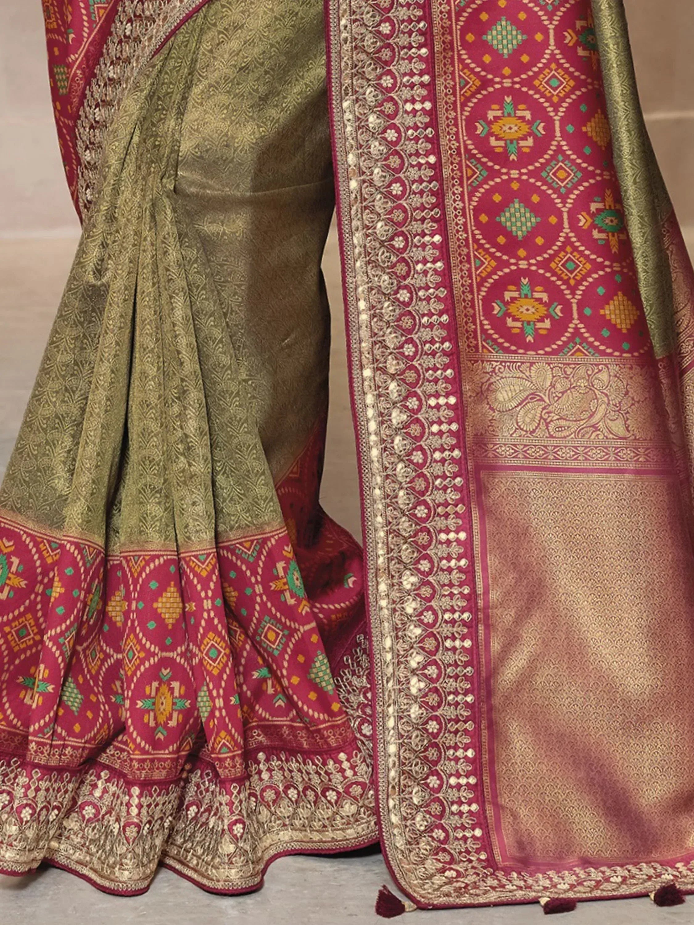 Olive green and maroon designer saree with intricate gold embroidery and geometric border patterns
