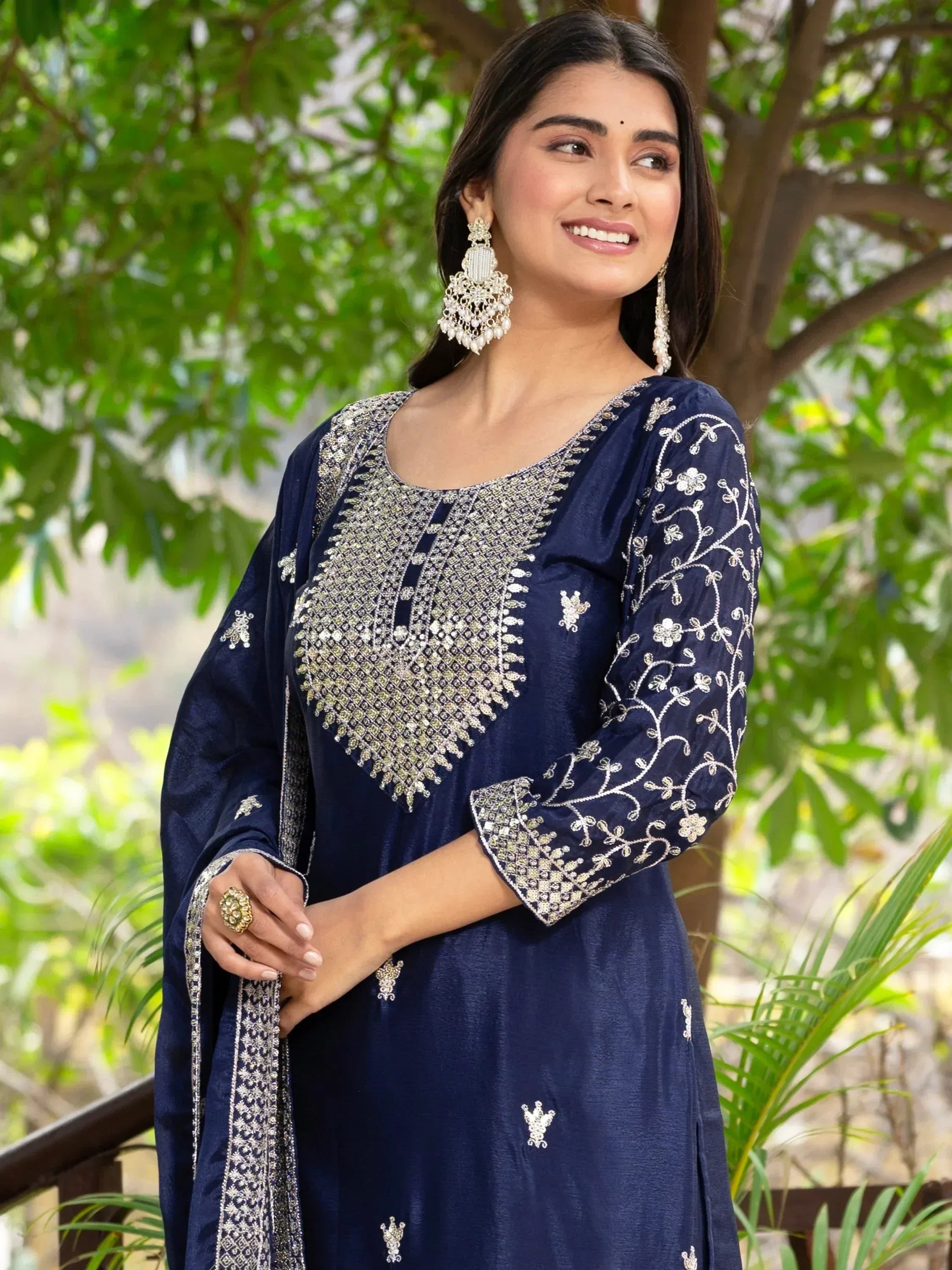 Navy blue embroidered ethnic kurti with floral detailing, paired with statement earrings for festive occasions.