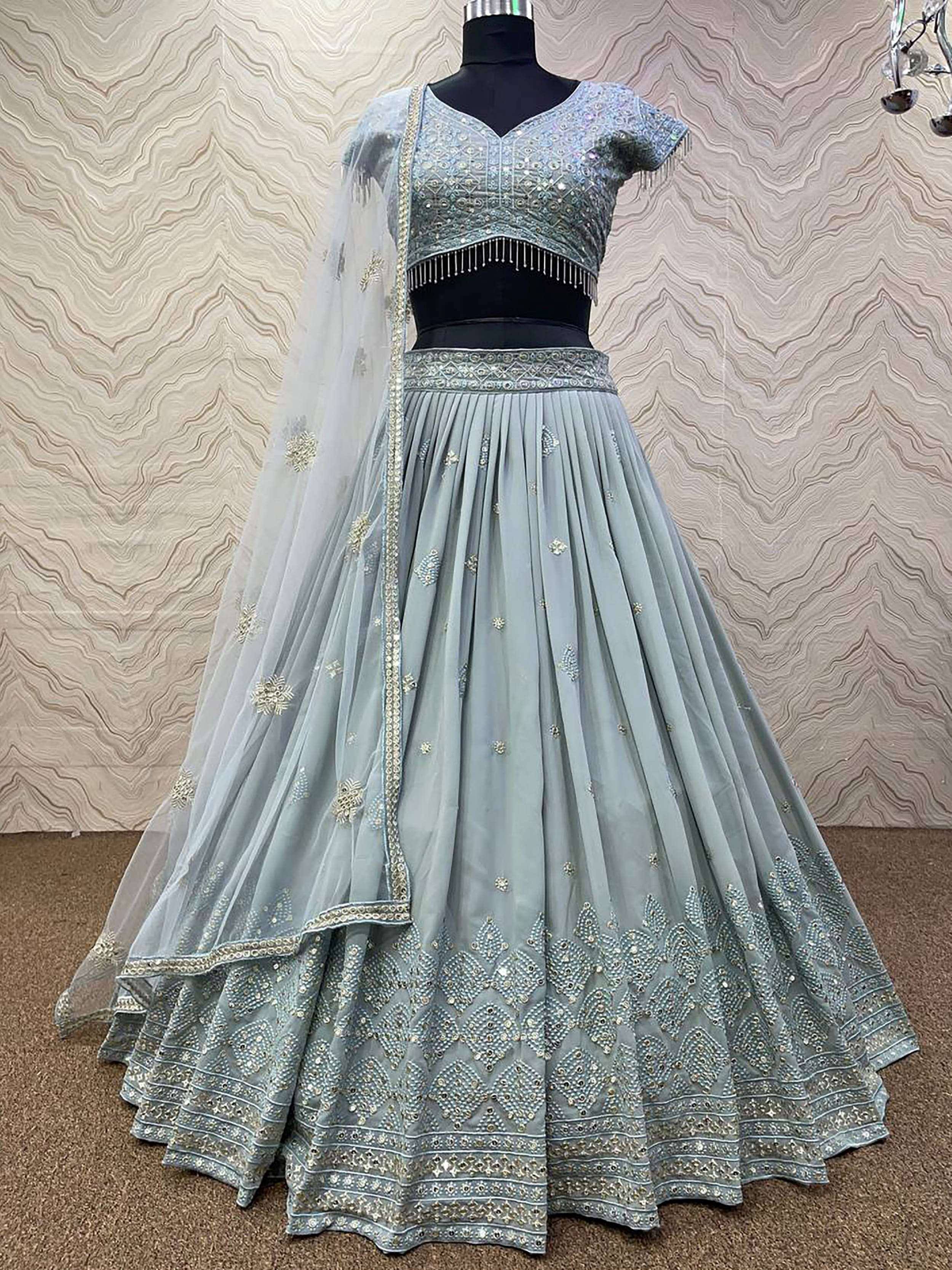 Light blue designer lehenga choli with heavy embroidery and dupatta, perfect for Indian weddings and festive occasions.
