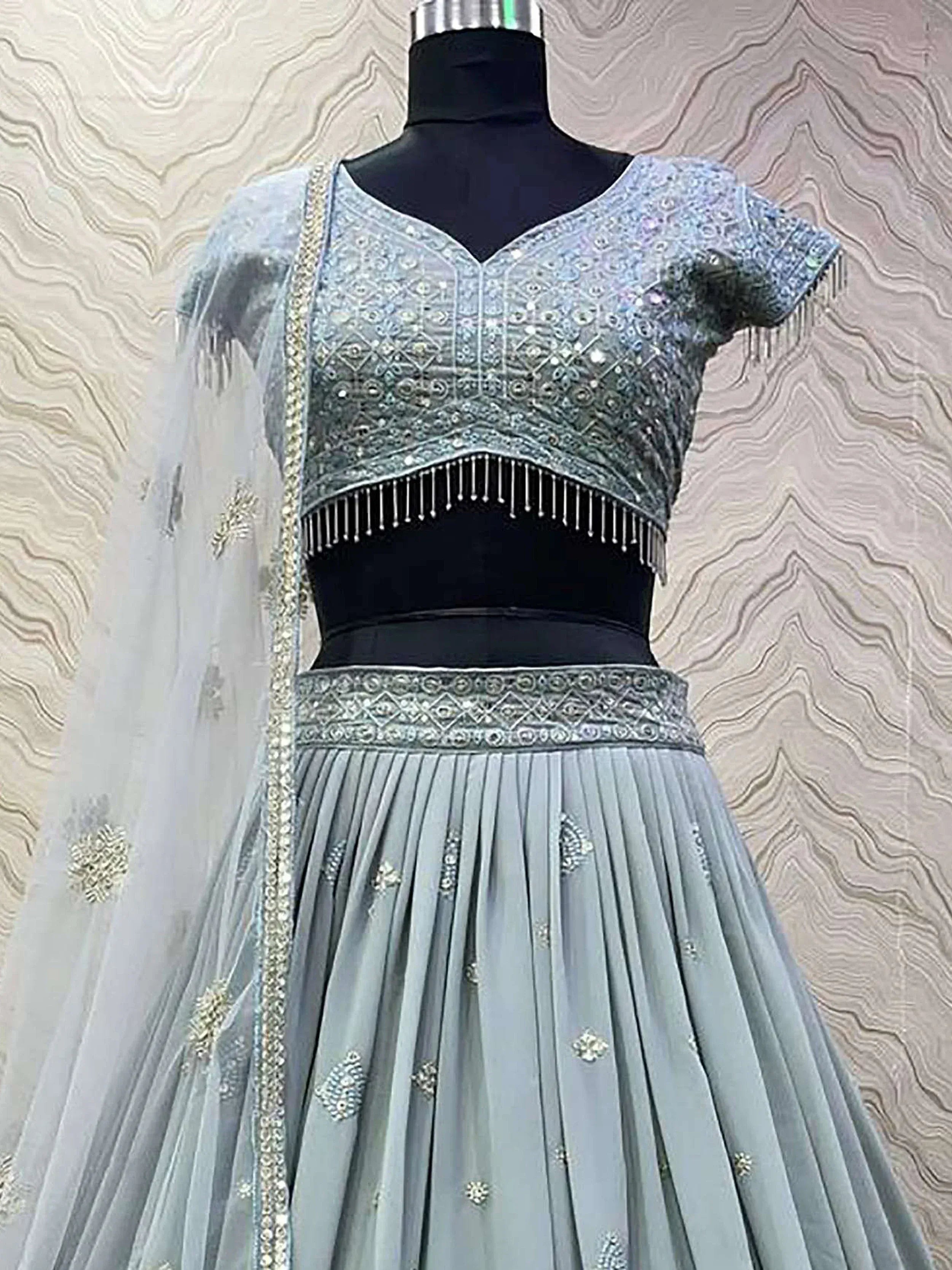 Light blue embroidered lehenga choli with sequins, fringe, and dupatta, displayed on mannequin