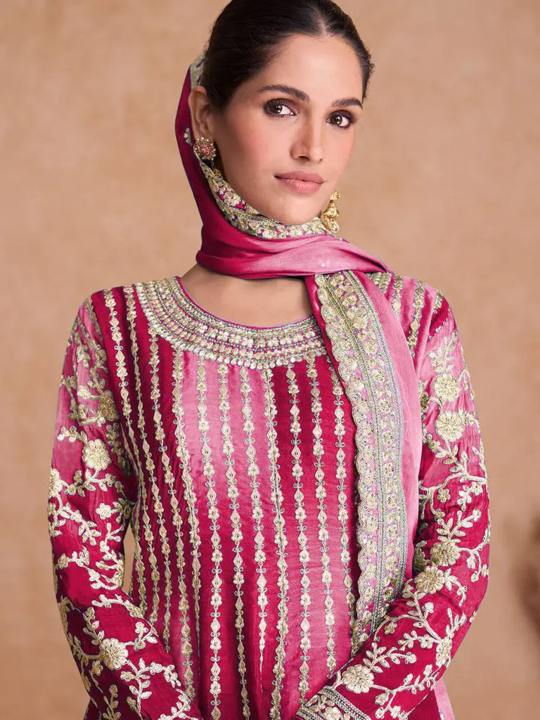Woman wearing a pink embroidered traditional outfit with a matching dupatta\