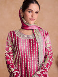 Woman wearing a pink embroidered traditional outfit with a matching dupatta\
