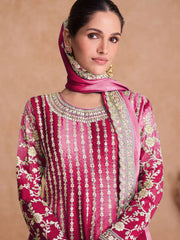 Woman wearing a pink embroidered traditional outfit with a matching dupatta\