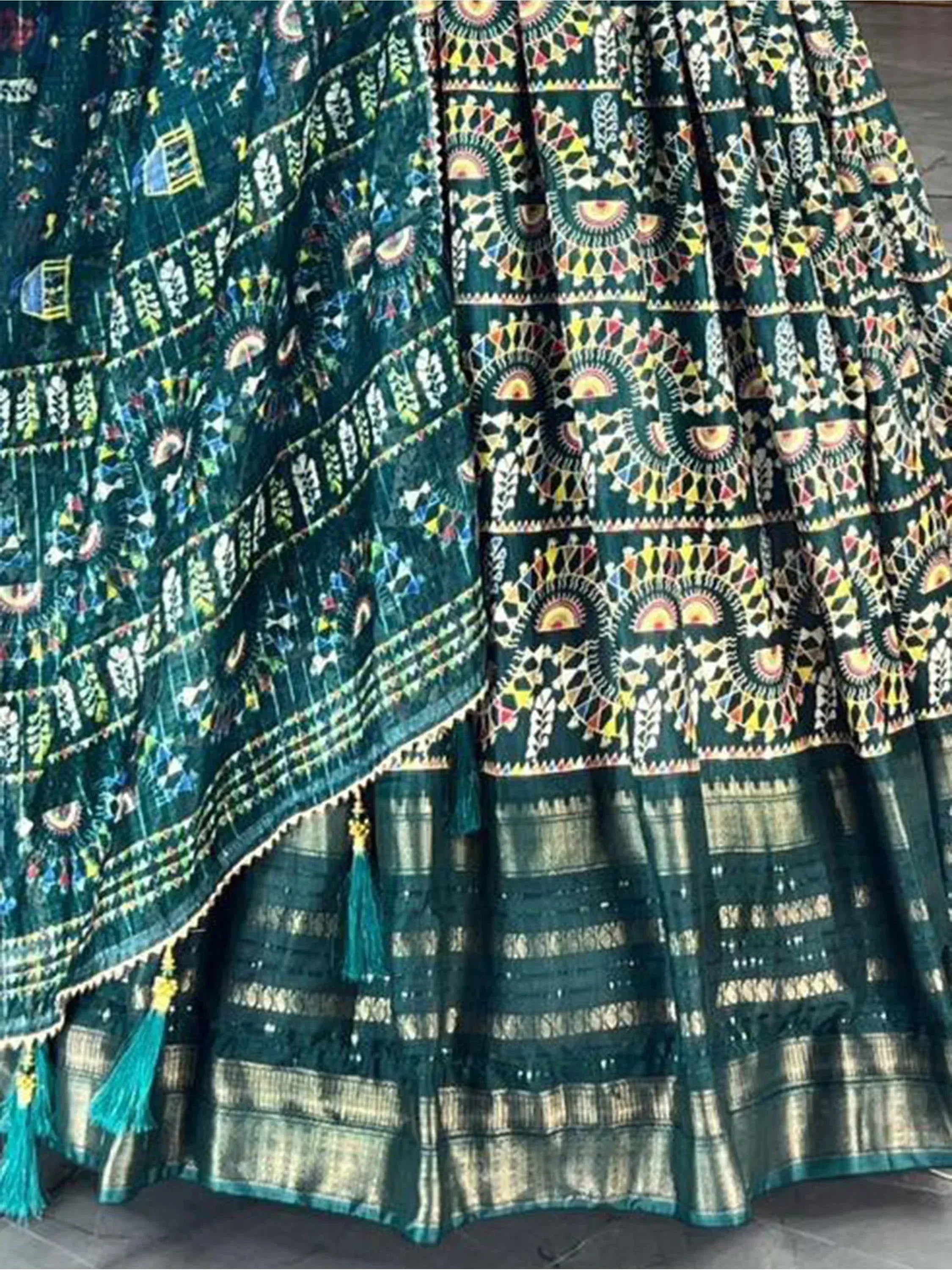 Emerald green ethnic lehenga with intricate geometric embroidery and tassel detailing, perfect for Indian weddings.
