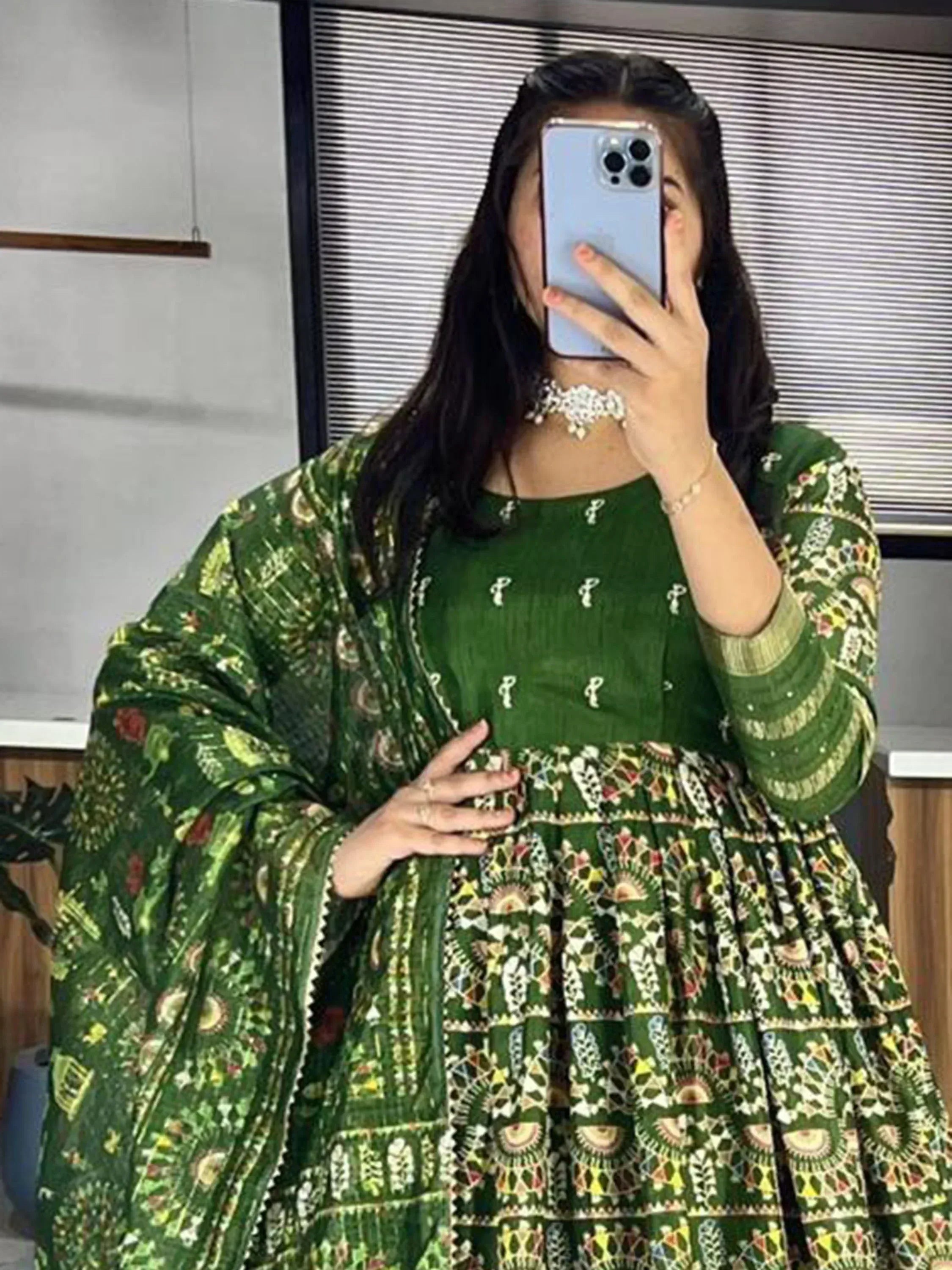 Woman in green printed ethnic gown with matching dupatta, perfect for Indian occasions and festivals.