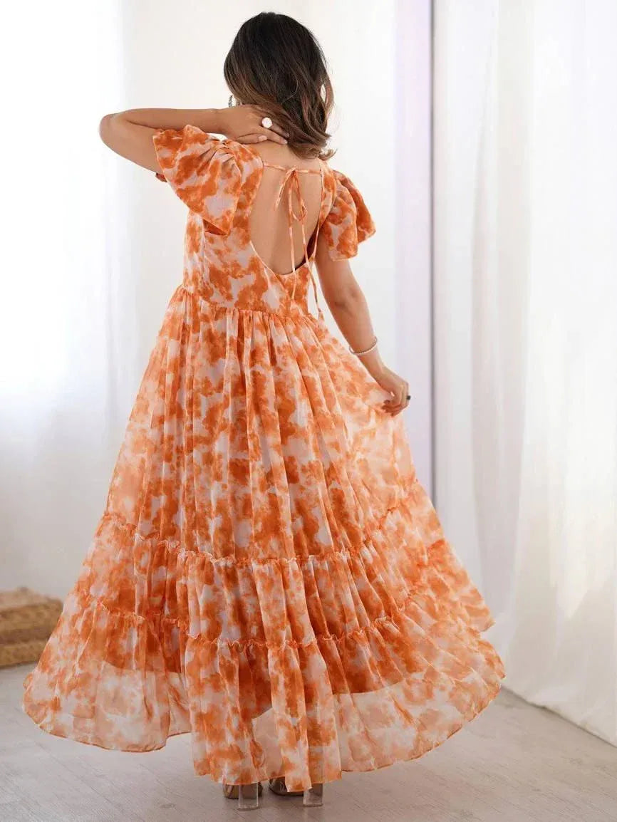 Woman in orange and white tie-dye ethnic gown with open back and ruffle sleeves