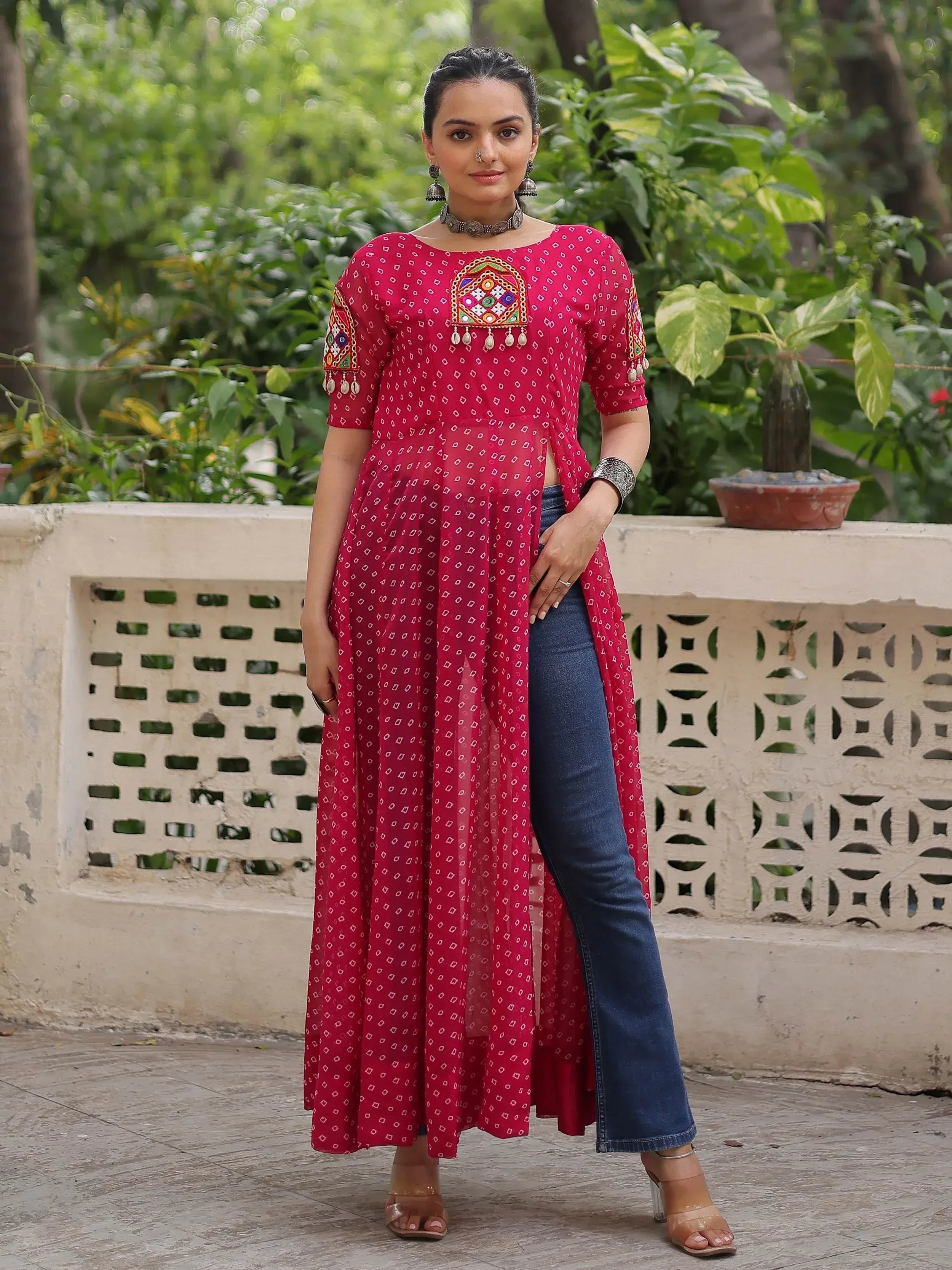 Red ethnic kurti with mirror work and side slit, paired with jeans, for women's Indian wear