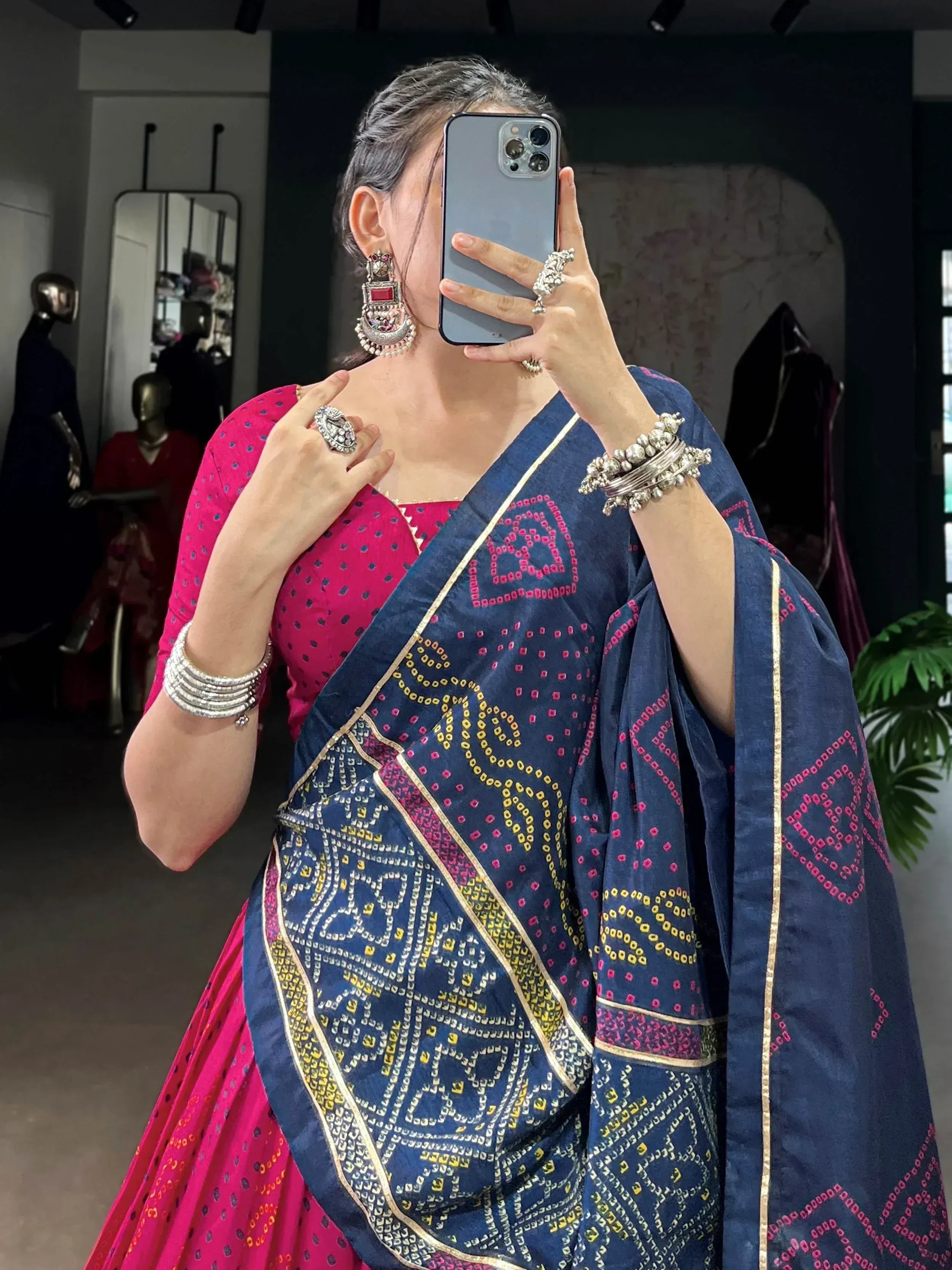 Woman in navy blue and pink ethnic saree with mirror work, gold border, and traditional jewelry