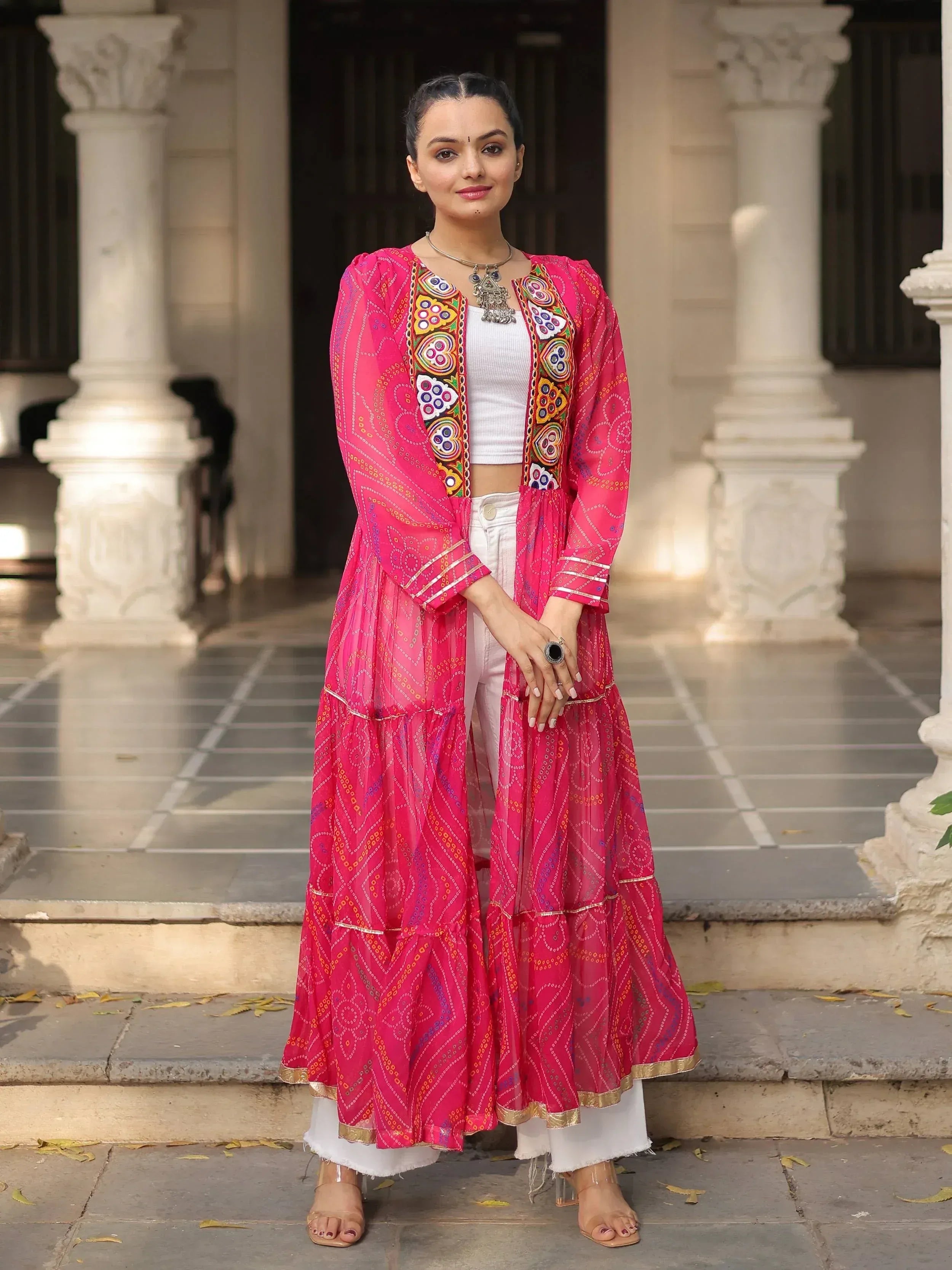 Pink embroidered ethnic jacket with white pants, perfect for Indian fashion trends