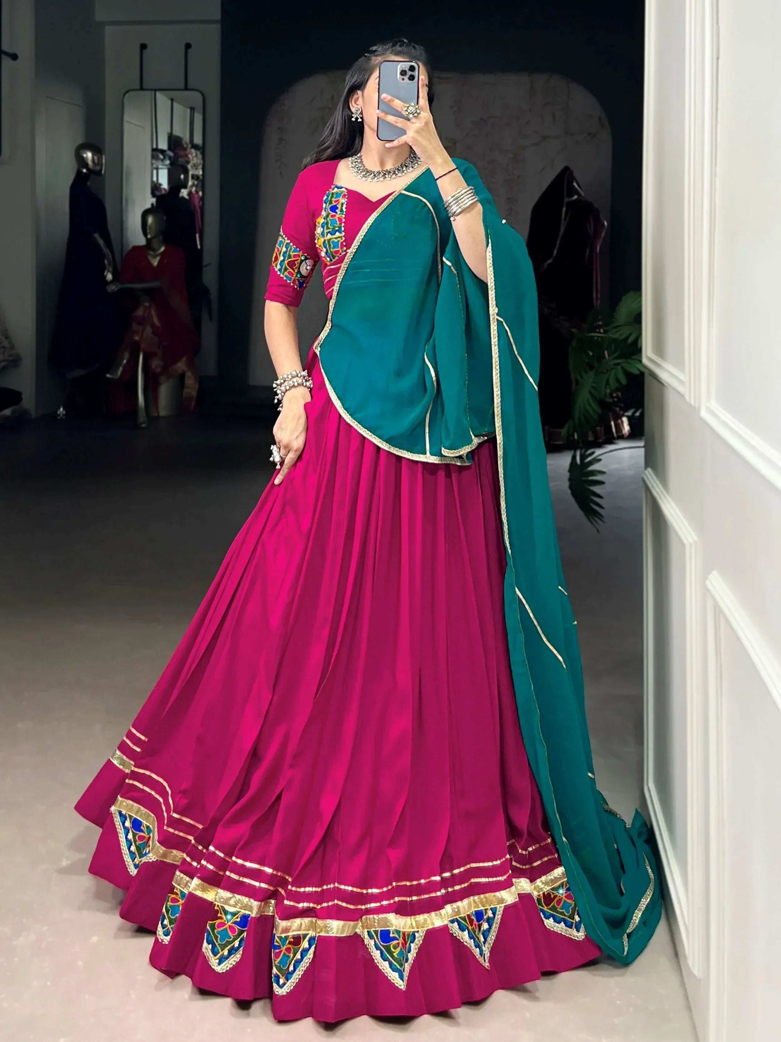 Fuchsia lehenga choli with green dupatta, colorful embroidery, and gold trim for Indian ethnic wear