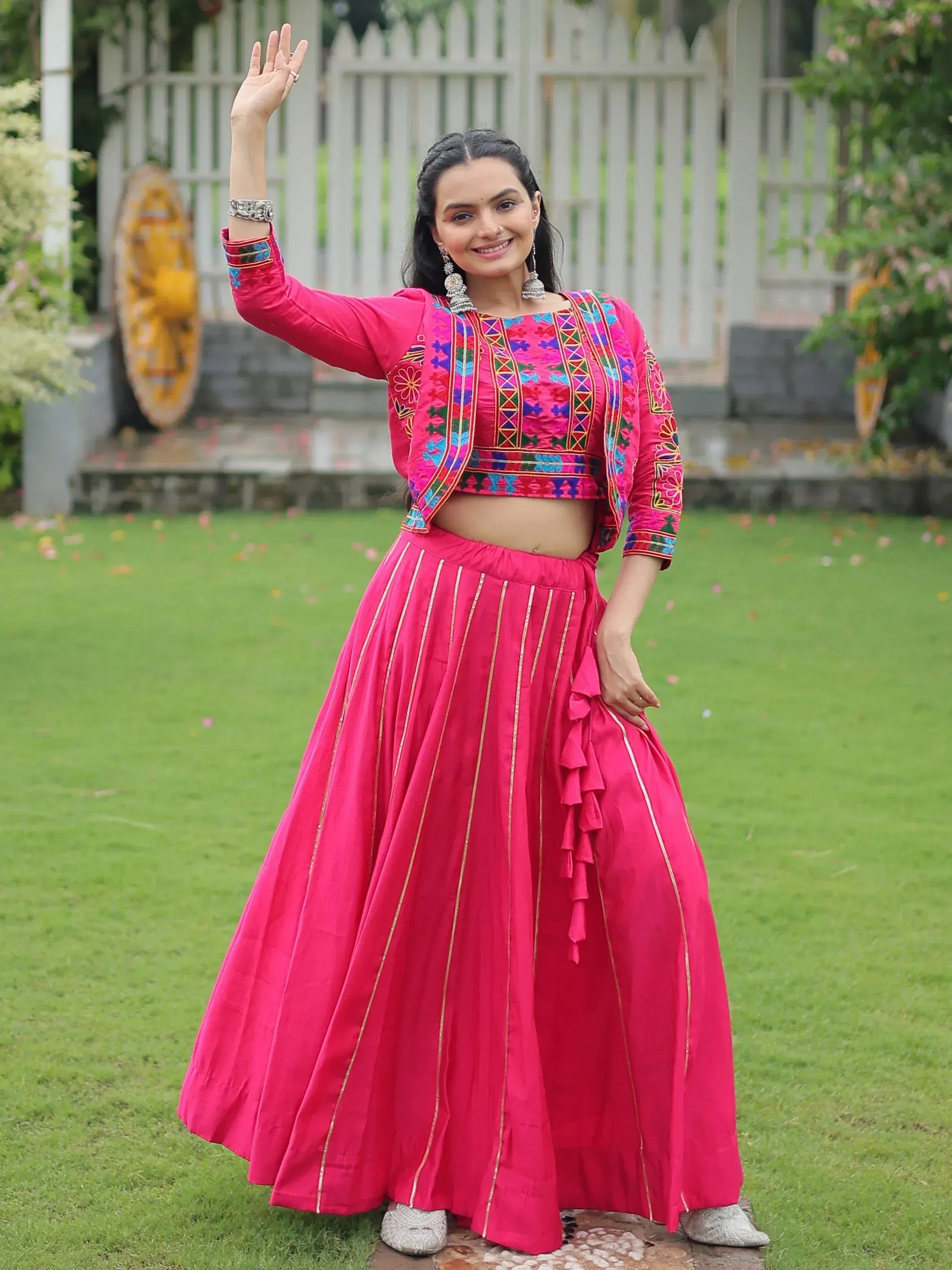 Vibrant pink embroidered lehenga choli with gold stripes, perfect for Indian ethnic wear