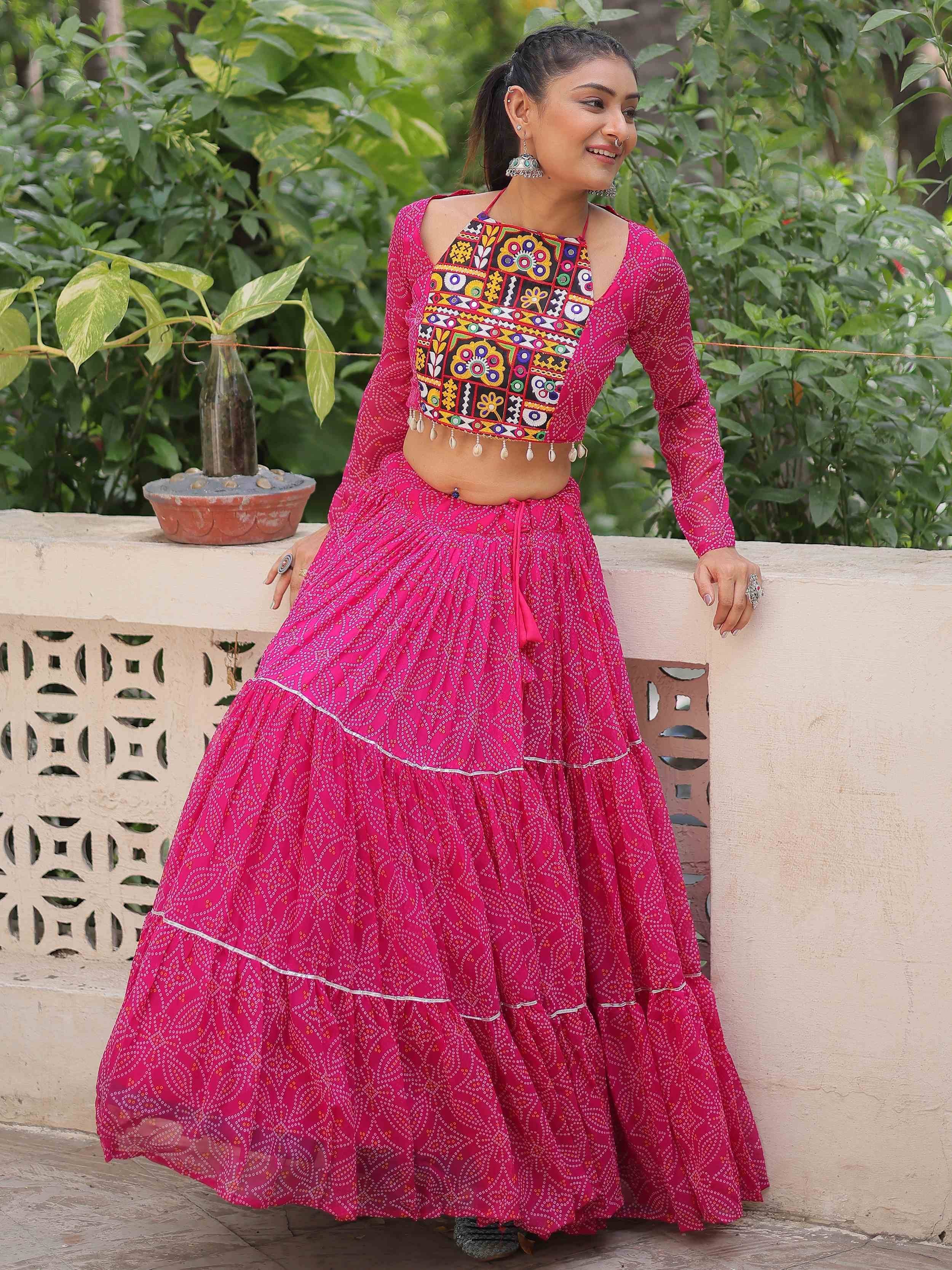 Pink ethnic lehenga choli with mirror work and tiered skirt, perfect for festive occasions