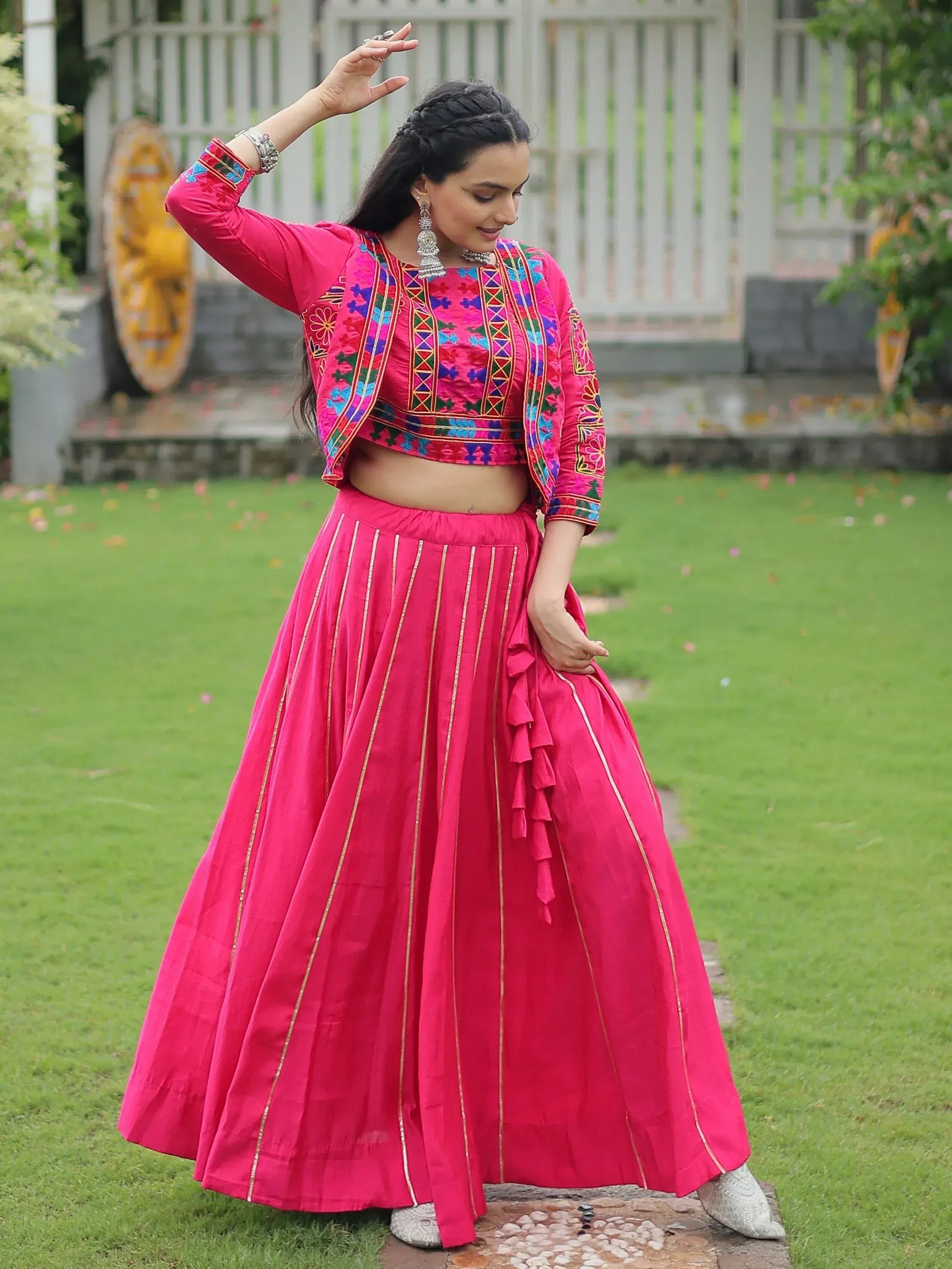 Vibrant pink embroidered lehenga choli with gold stripes, perfect for Indian ethnic wear
